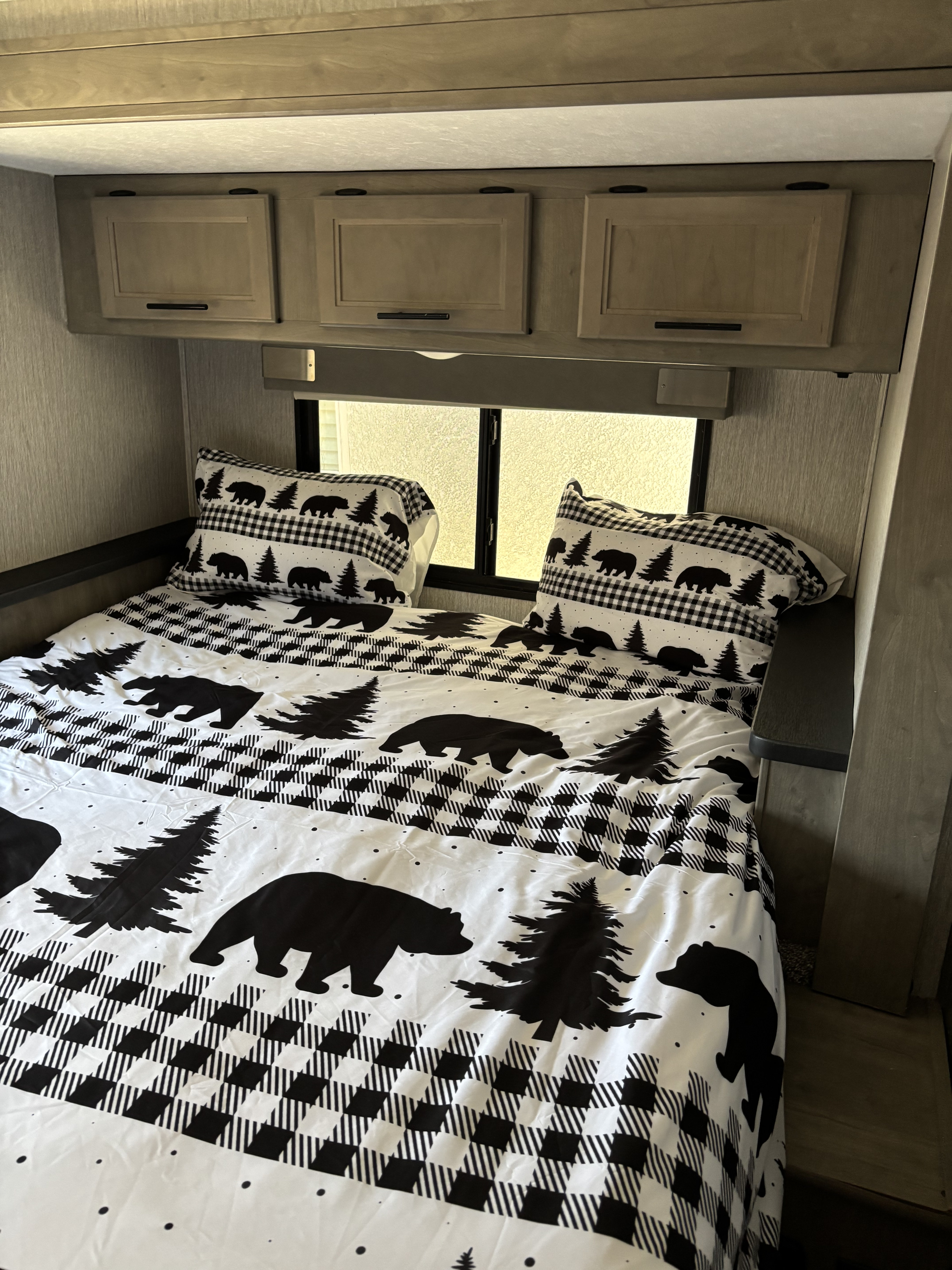 RV rental: Cozy camper bedroom with black & white bear-themed bedding & storage cabinets.. Forest River Coachmen Freelander 2021