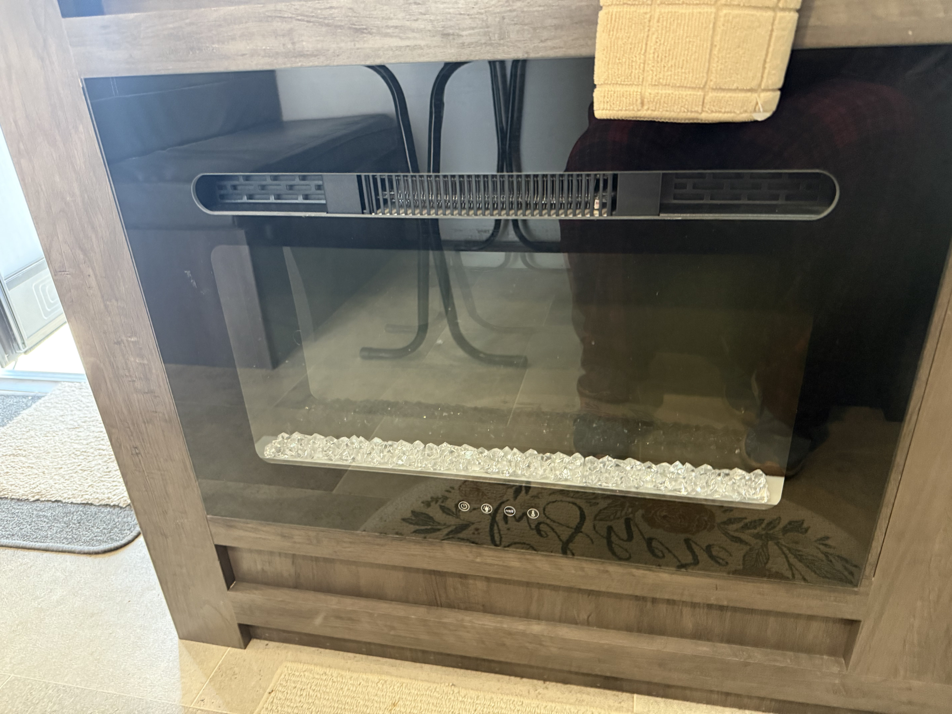 This RV rental features an electric fireplace and heater with a glass front, top vent, and bottom controls for comfort.. Keystone RV Coleman Lantern 17B 2022