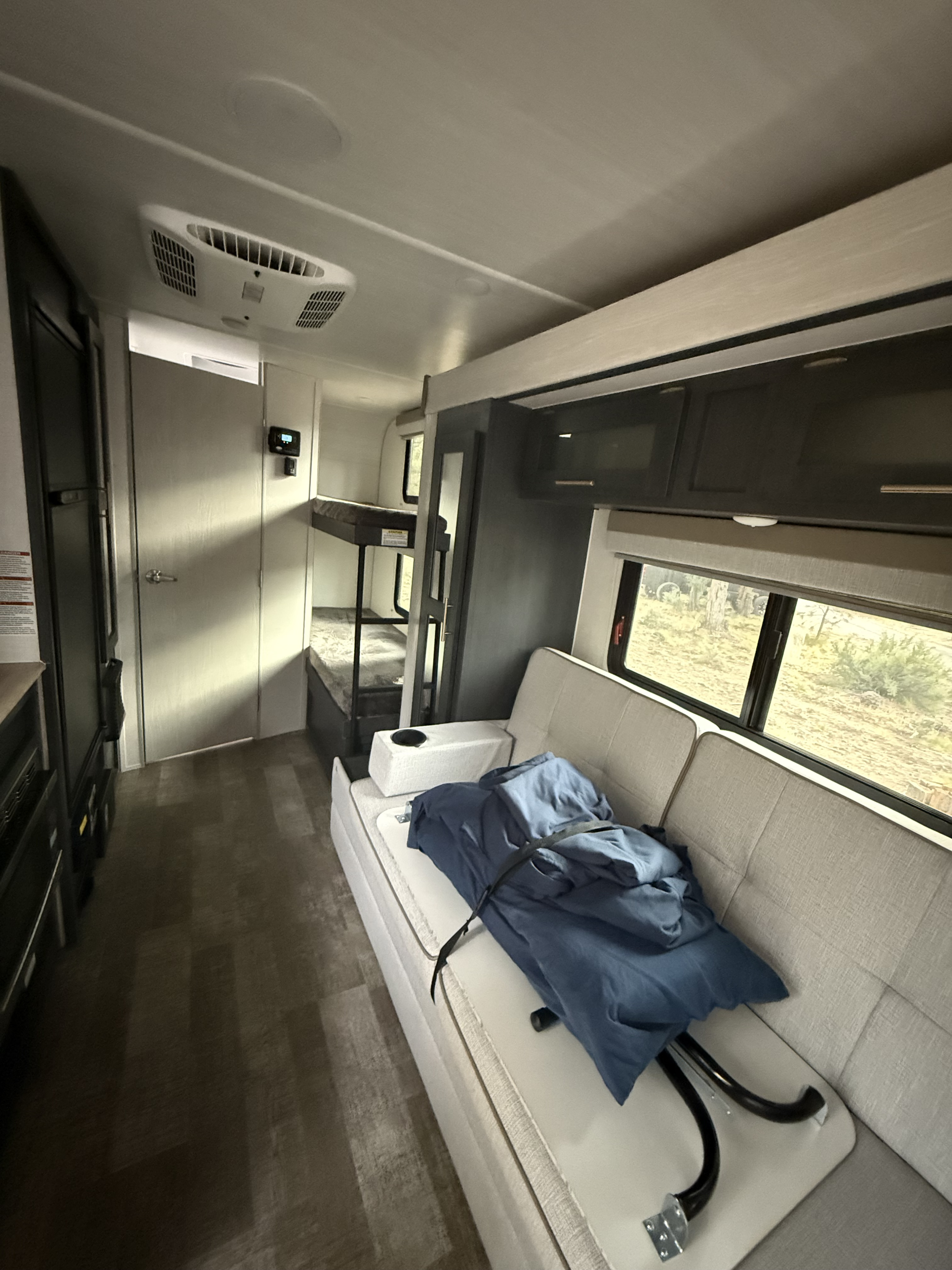 Cozy RV rental interior featuring a sofa, bunk beds, and compact amenities, designed for comfortable travel.. R-Pod R-Pod Trailer 2023