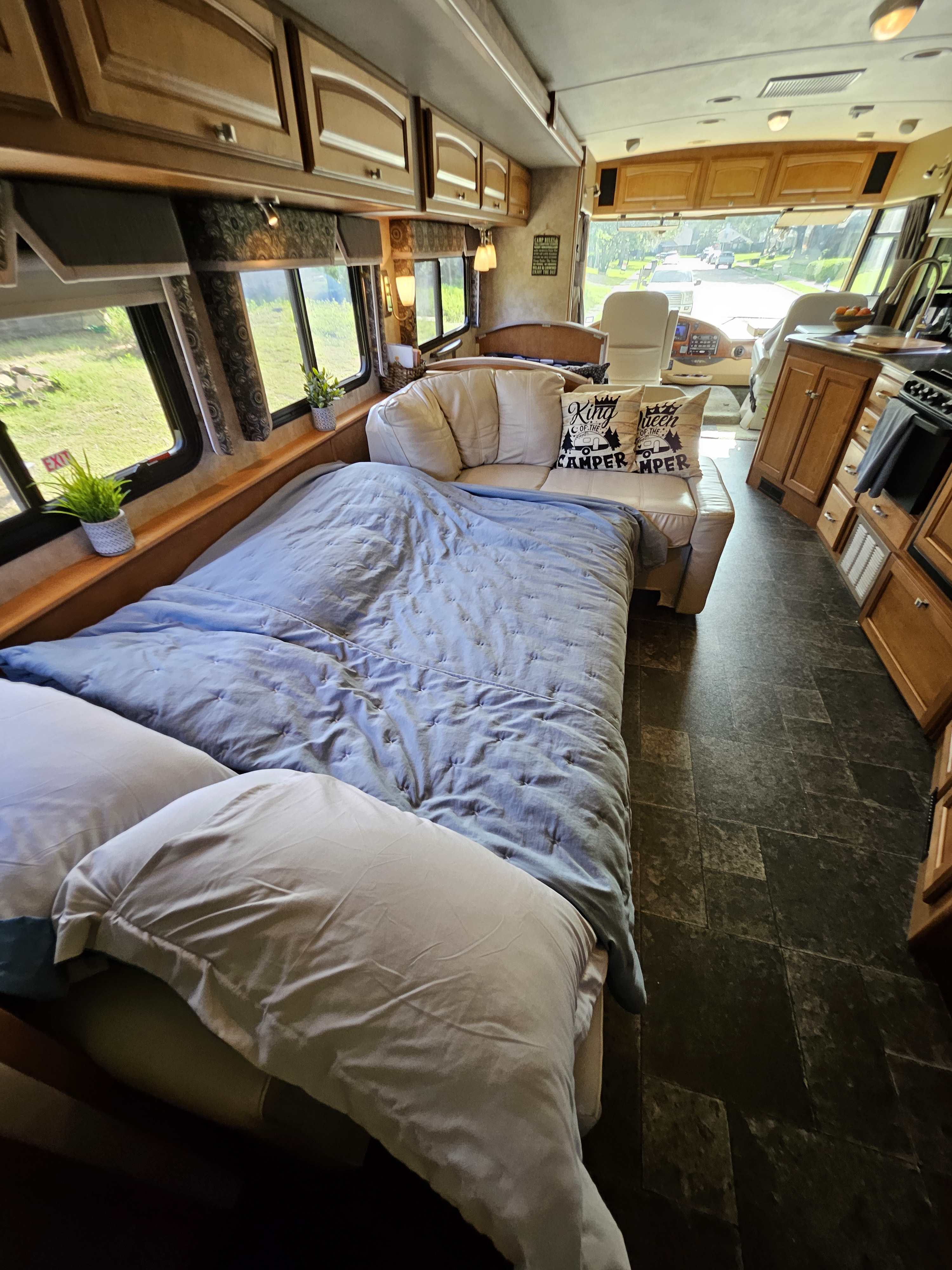 Inviting RV rental interior featuring a comfortable bed, sofa with pillows, and a well-equipped kitchen.. Winnebago Vista 2013
