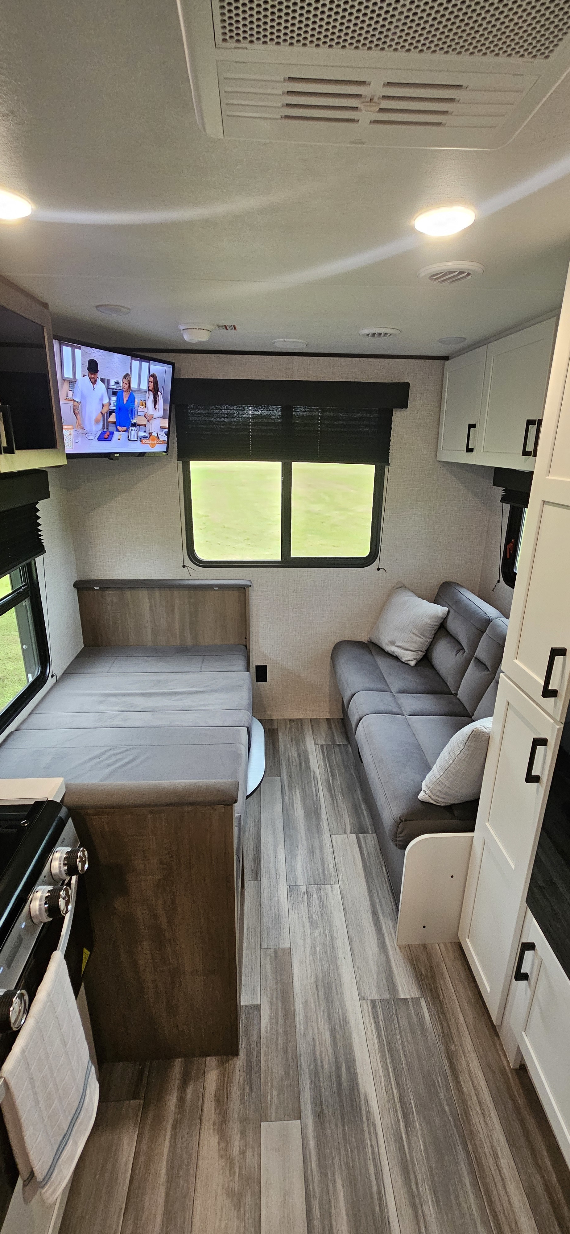 Modern RV rental interior with cozy dinette bed, sofa, kitchen, and TV for comfortable travel.. Jayco Jay Flight SLX 210 QB 2025