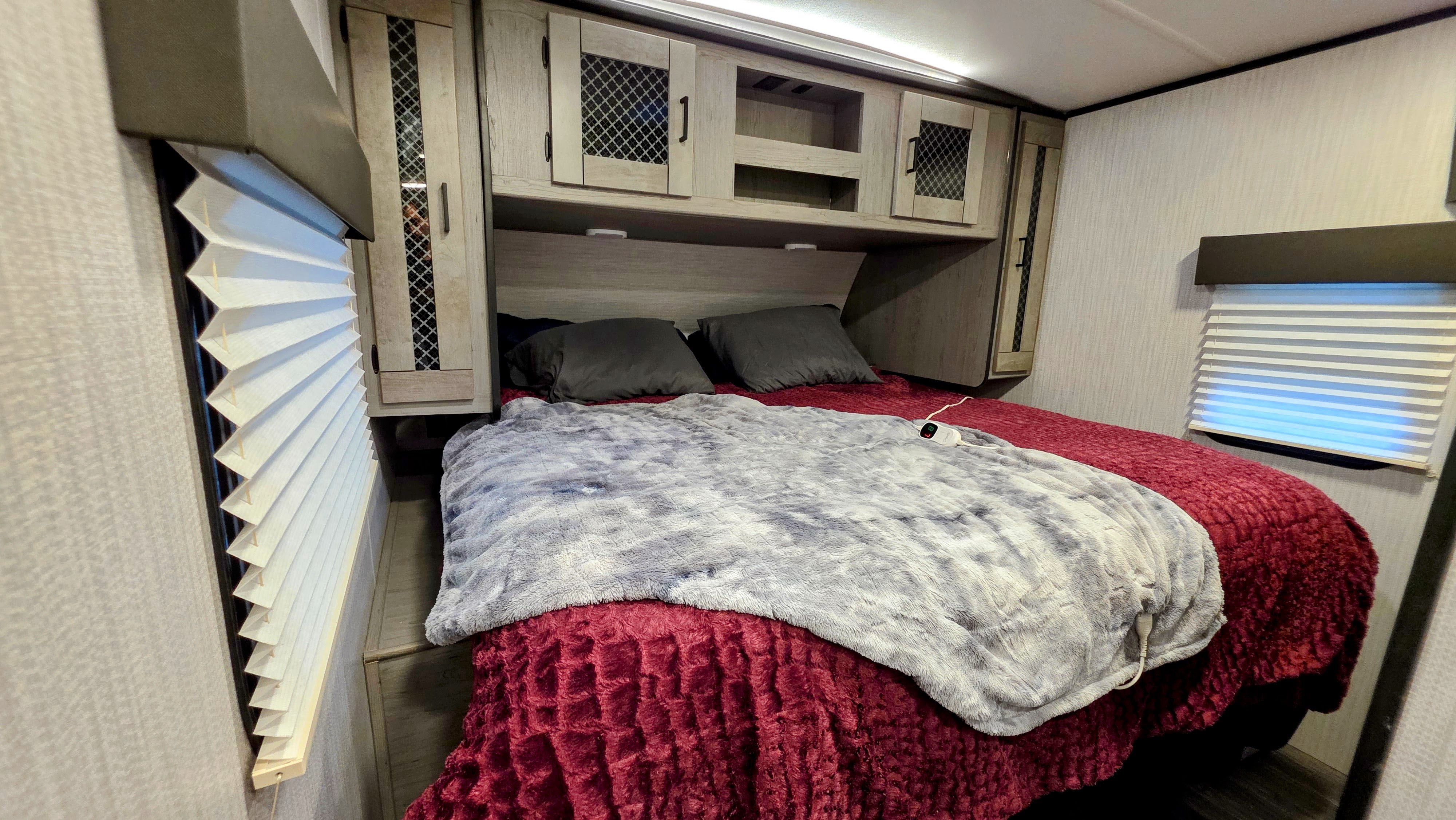 Cozy RV rental bedroom with a comfy bed, heated blanket, and convenient overhead storage for a relaxing stay.. Heartland RVs Mallard 2021