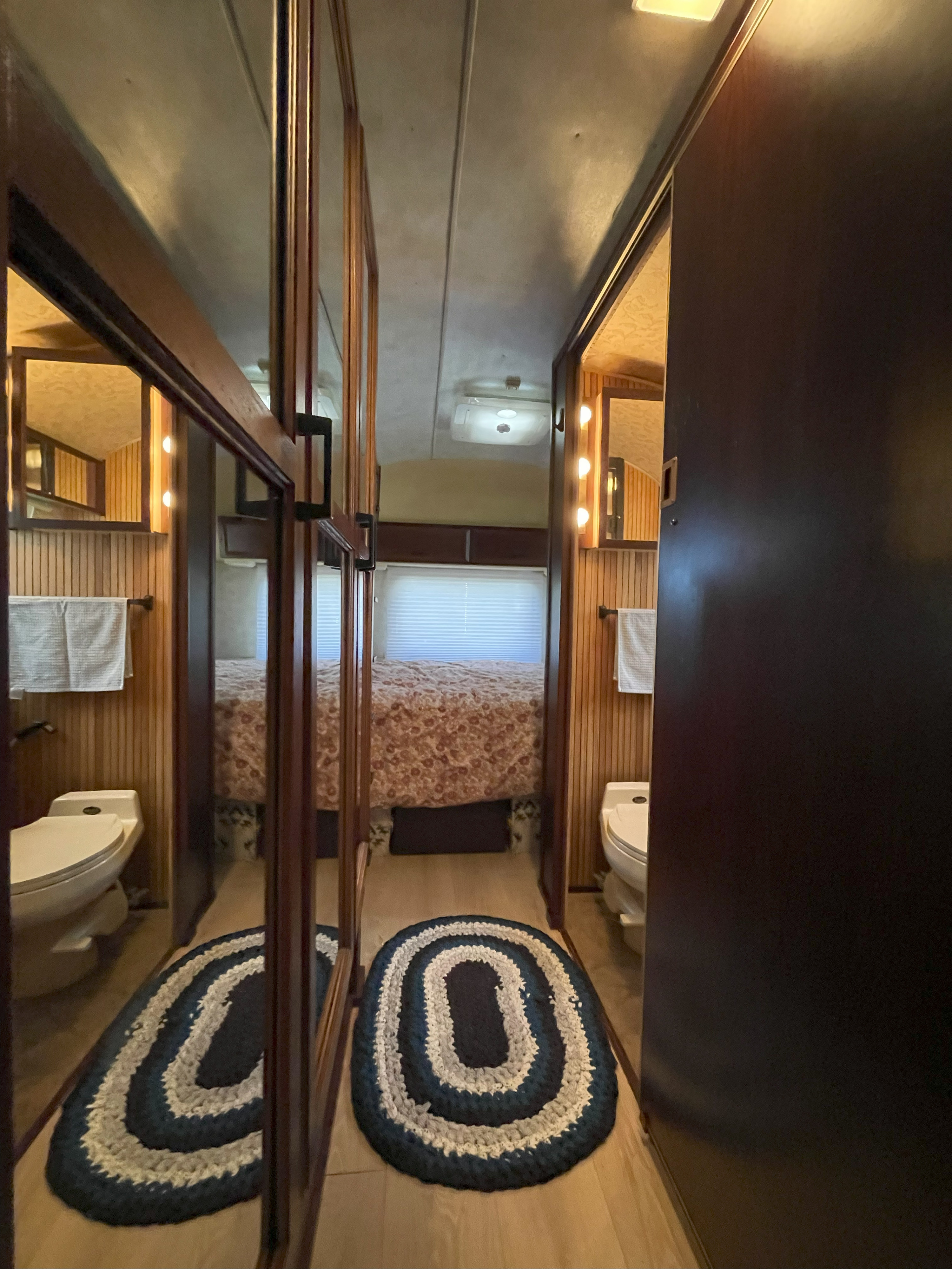 Cozy RV rental interior: hallway with mirrored doors reflecting a bathroom and leading to a comfy bedroom.. Airstream Excella 1990