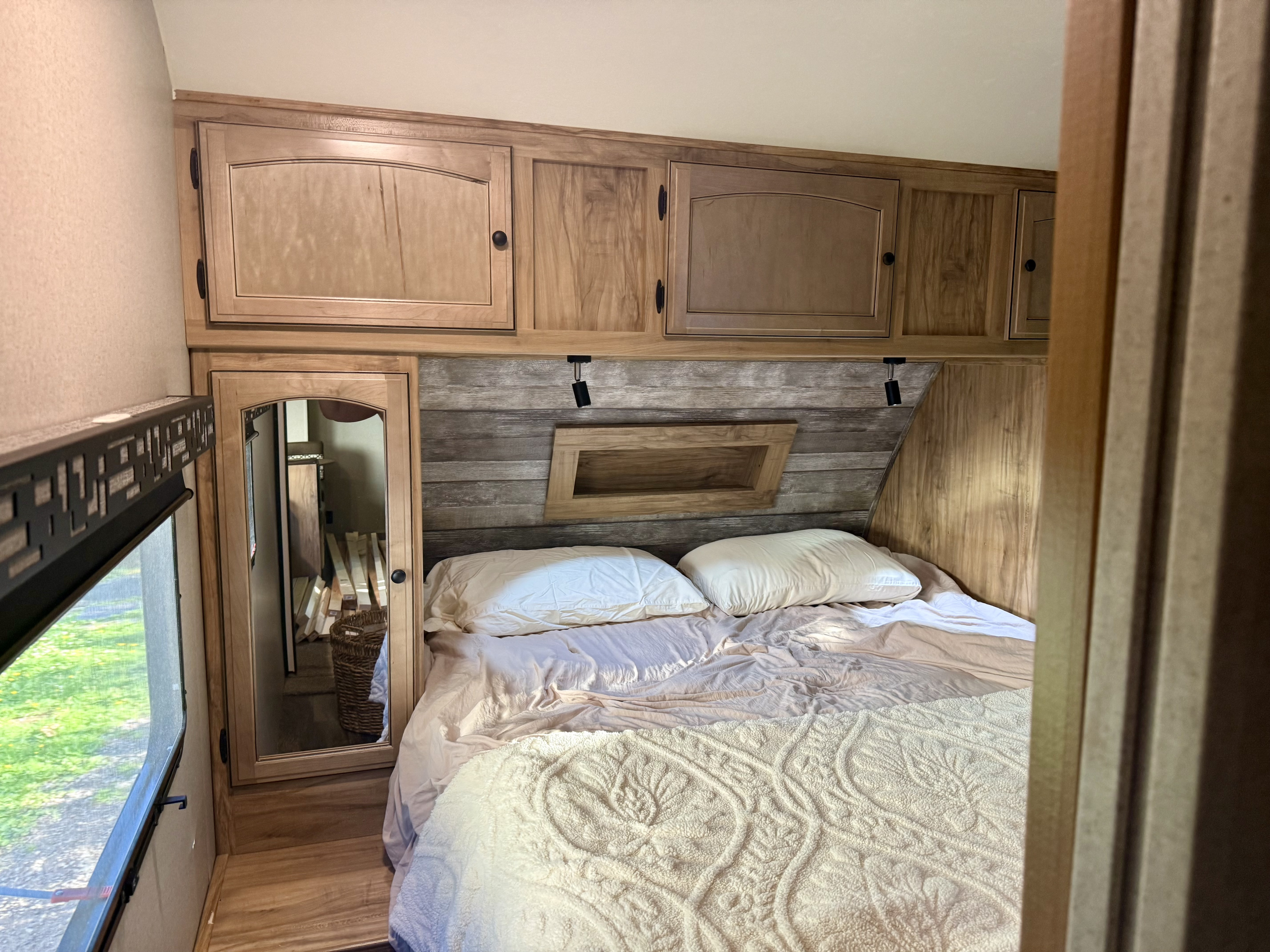 This RV rental offers a cozy bedroom with overhead storage, a comfy bed, and a mirrored wardrobe.. Coachmen Freedom Express Ultra Lite Maple Leaf Edition 2019