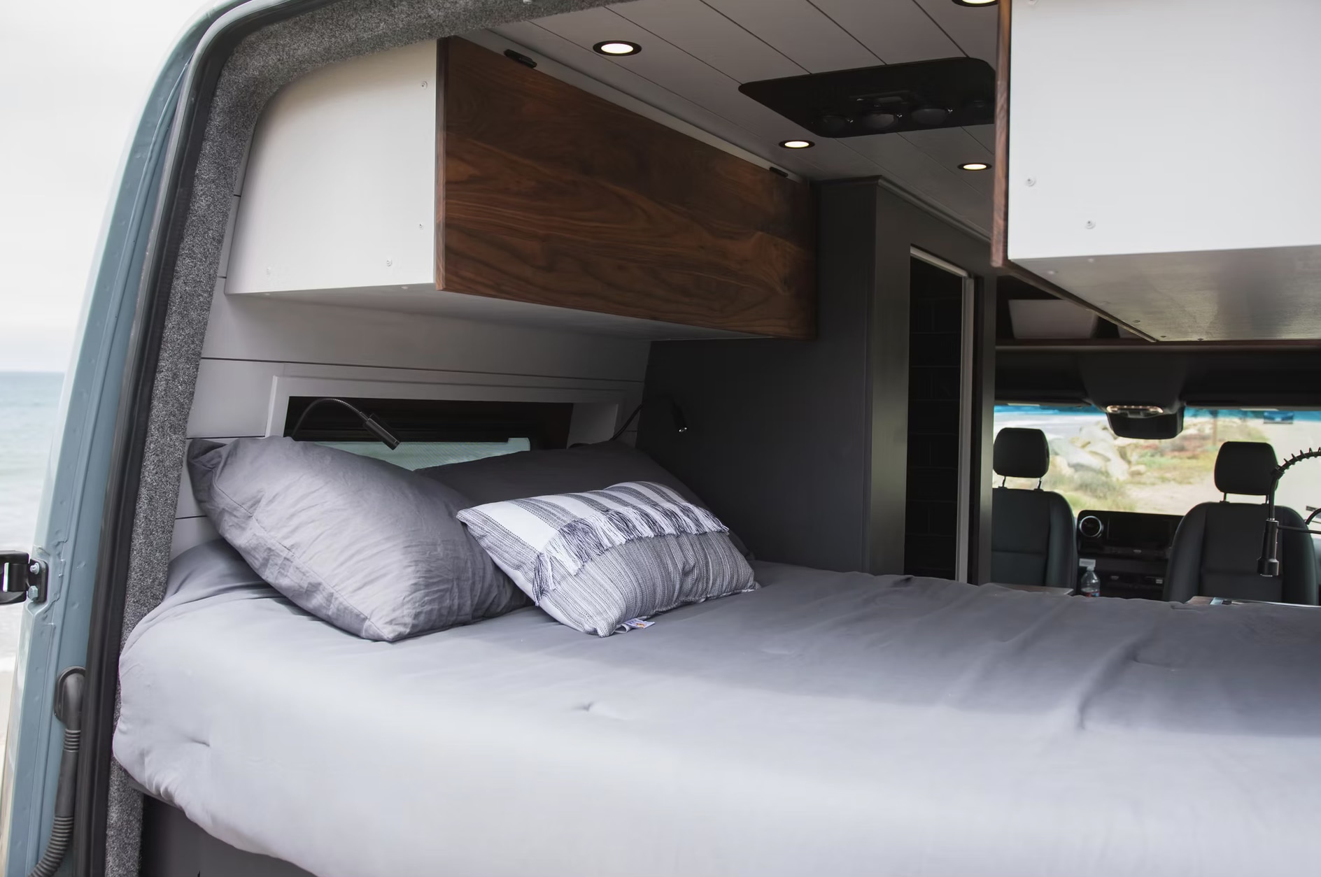 Cozy RV rental interior with a comfy bed & ocean view. Ideal for your next road trip getaway in this spacious camper van.. Mercedes-Benz B class campervan MB 140 2021
