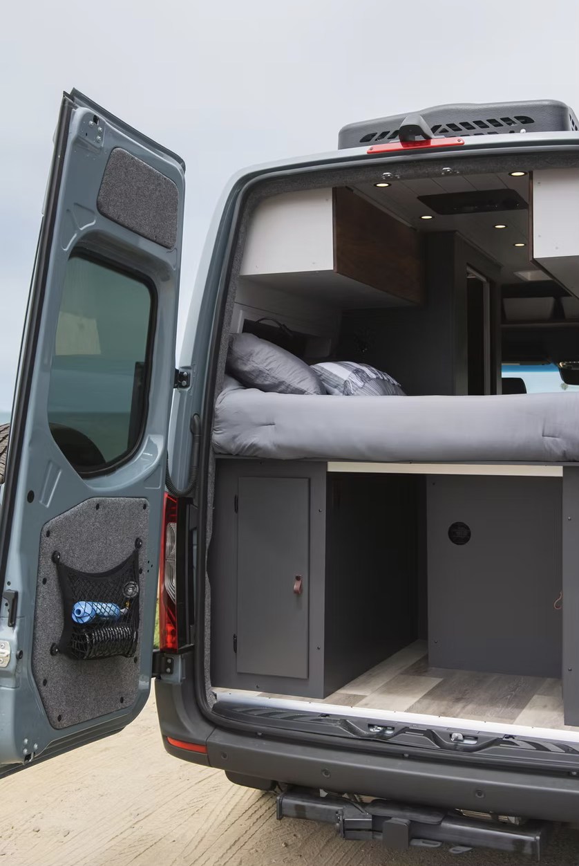 Open camper van rear reveals a cozy bed, under-bed storage, and organized interior, perfect for your next rv rental adventure.. Mercedes-Benz B class campervan MB 140 2021
