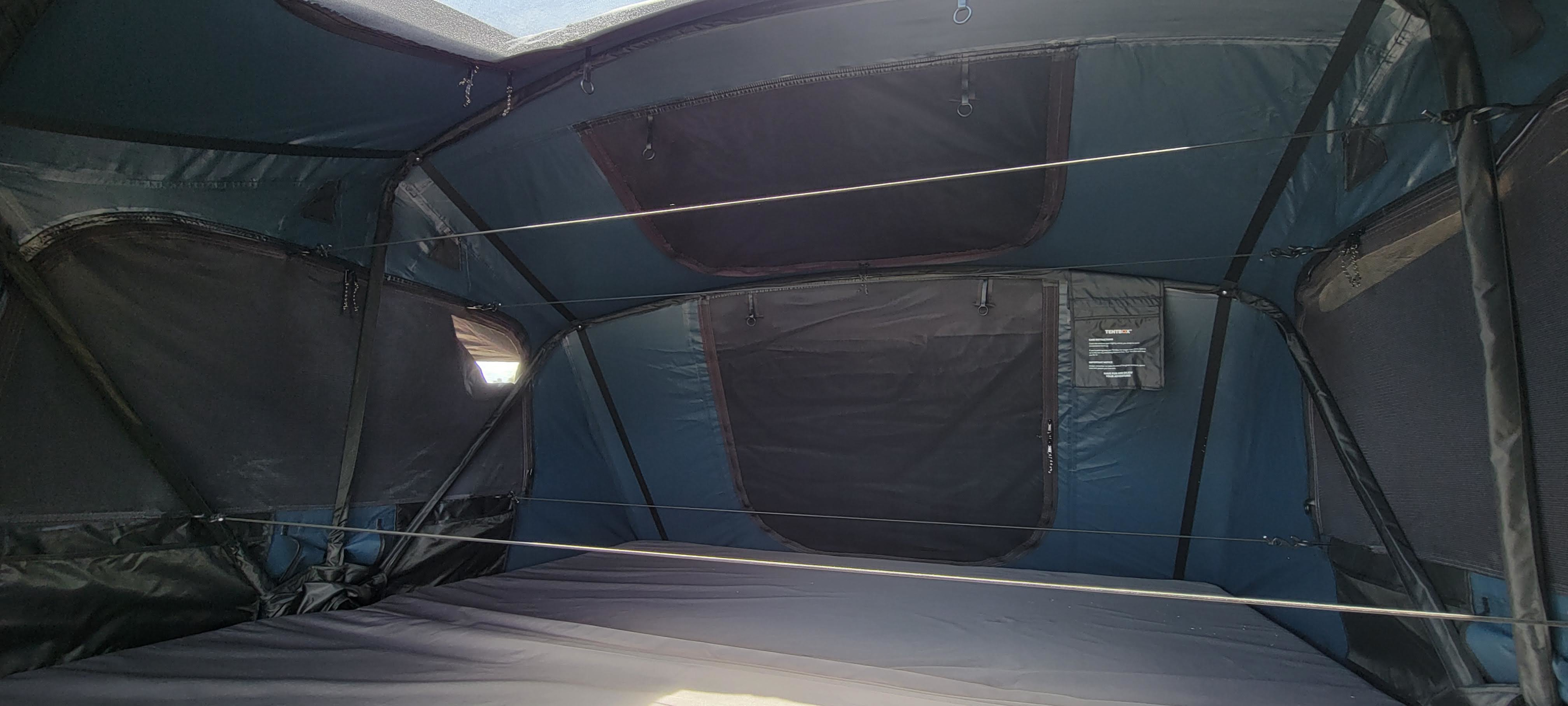 Cozy TentBox interior with mattress, screens, & storage, perfect for an RV rental camping adventure.. Custom Grunt 2025