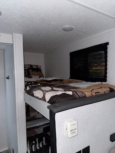 Cozy RV rental interior featuring themed bunk beds and a compact sleeping area, perfect for family adventures on the road.. Coachmen Coleman Rubicon 1628BH 2024