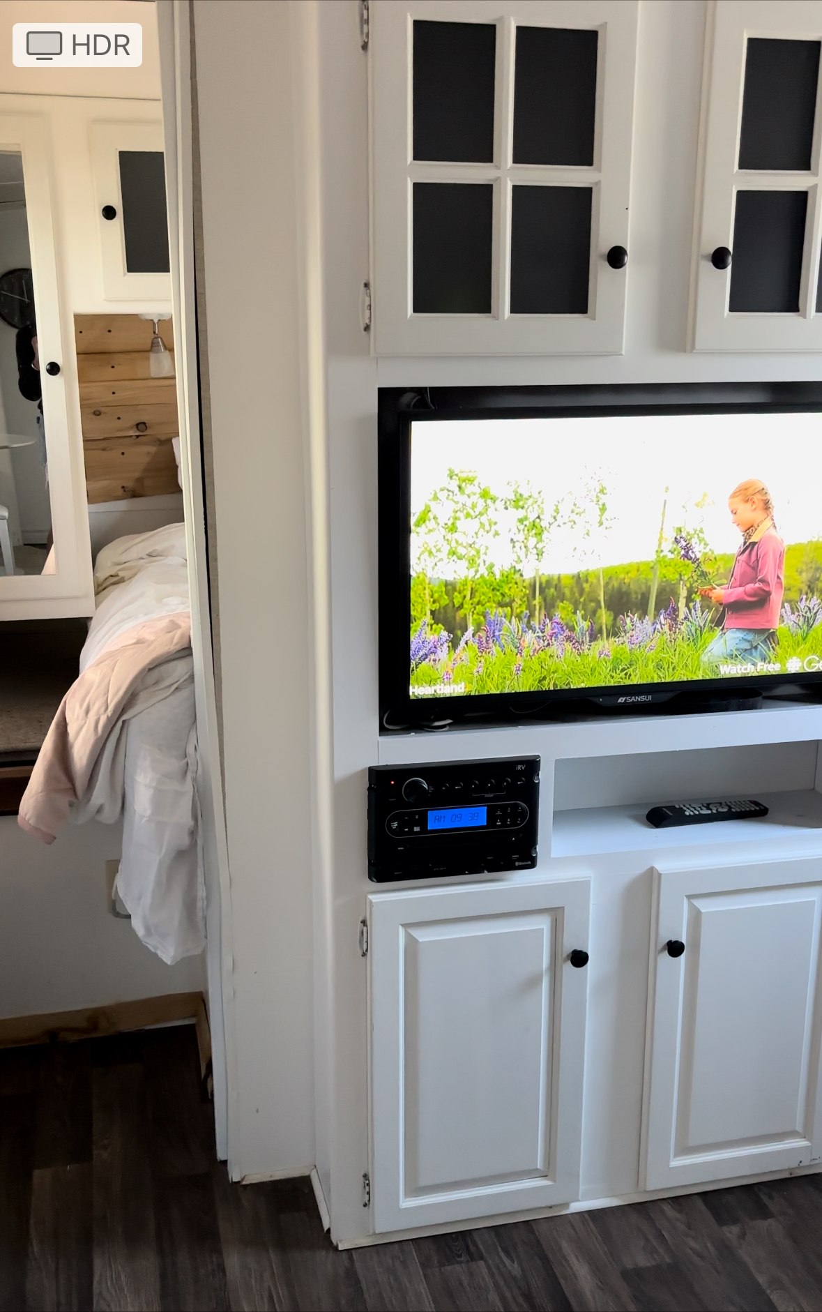 Experience comfort in this rv rental. Features a modern RV interior with a TV, entertainment system, white cabinets, & bed.. Jayco Jay Feather Ultra Lite 2019