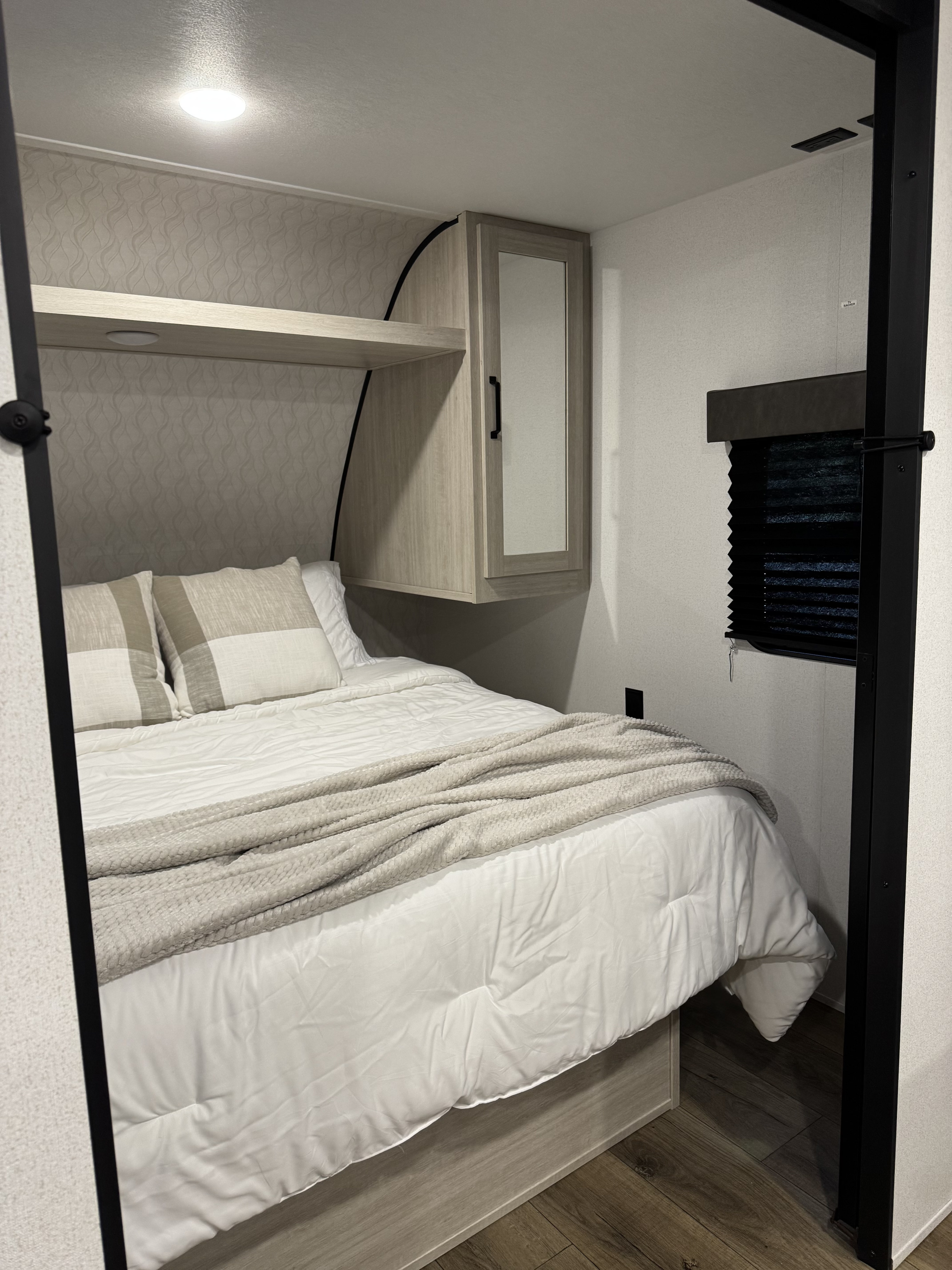 RV rental, compact bedroom with modern finishes, comfy bed, overhead storage, and efficient design.. Forest River Palomino Puma 2025