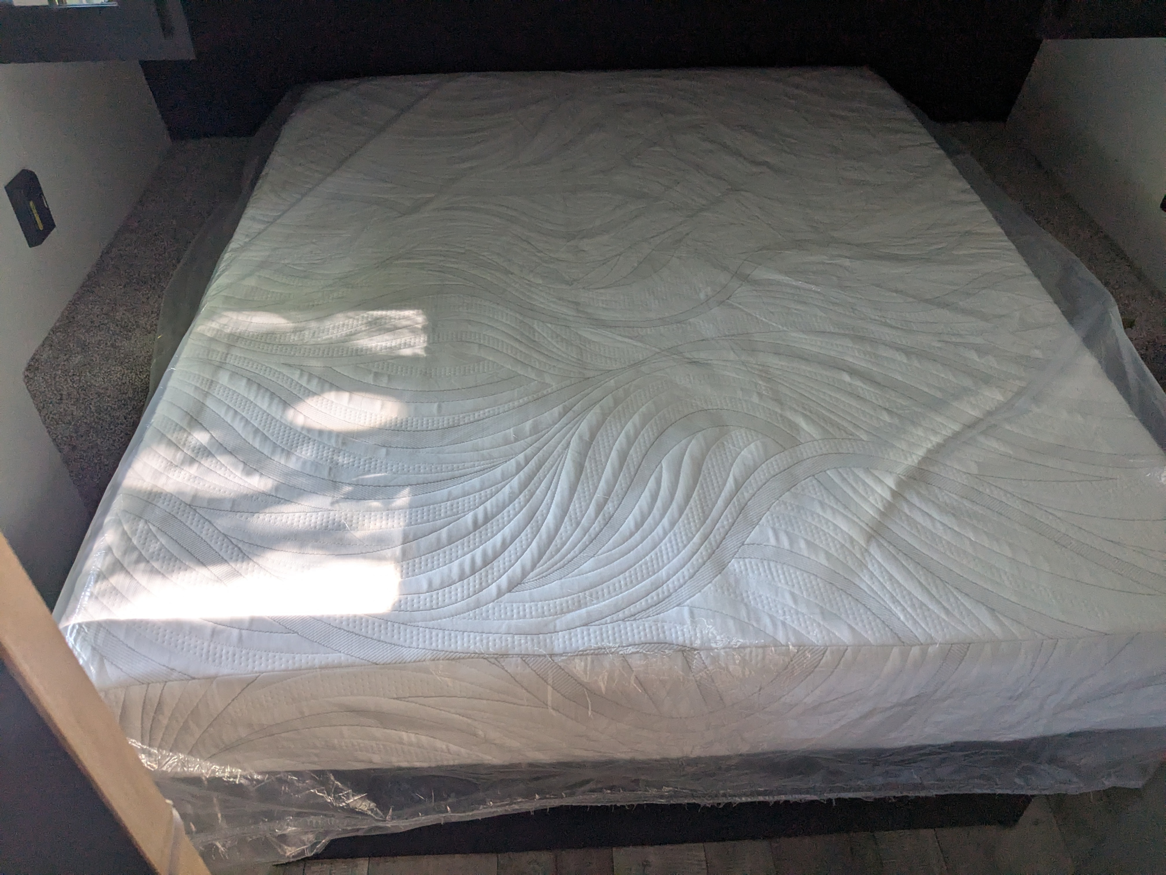 New RV rental mattress, still in plastic, ready for a comfortable night's sleep in this clean RV sleeping area.. Keystone RV Springdale 2022