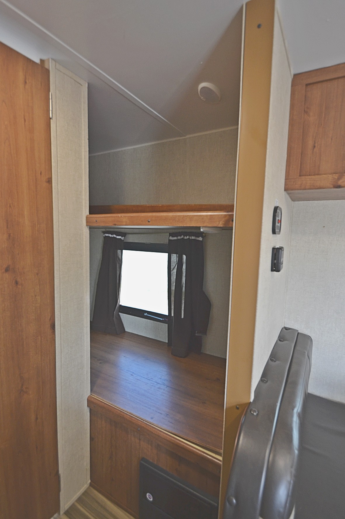 RV rental: Inside a cozy camper, this view shows bunk beds with a window, dark curtains, and wood flooring.. Gulf Stream Ameri-Lite 2017