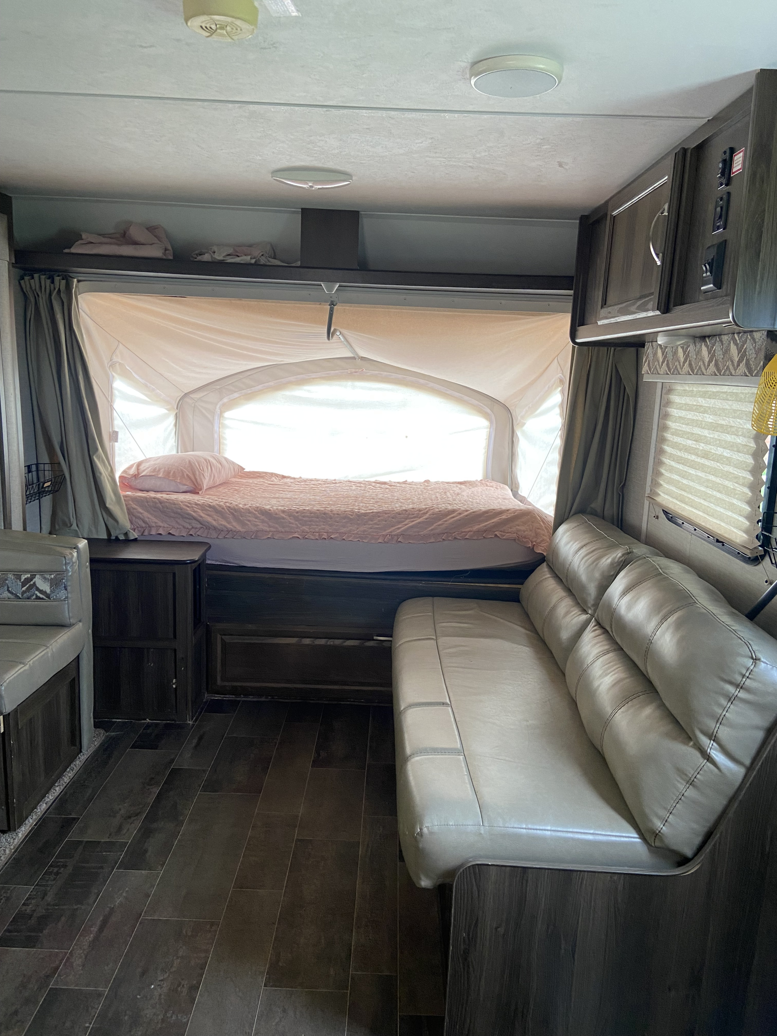Inside a cozy RV rental: A soft bed, light sofa, and dinette provide comfort for your travel adventures.. Keystone RV Bullet Crossfire 2018