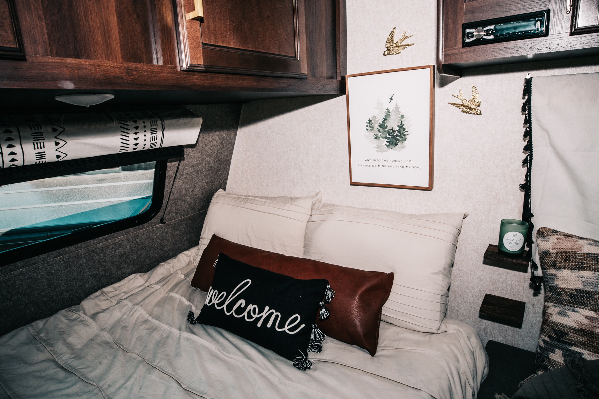 Relax in this cozy RV rental bedroom. It features nature-themed decor, a comfy bed, and a welcoming pillow.. Jayco Jay Flight SLX Baja Edition 2019