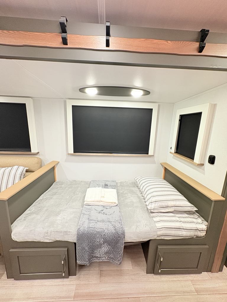 Spacious RV rental interior featuring a versatile bed/lounge area with comfy bedding, windows & ambient lighting.. Keystone Bullet Crosfire 290BHS 2025