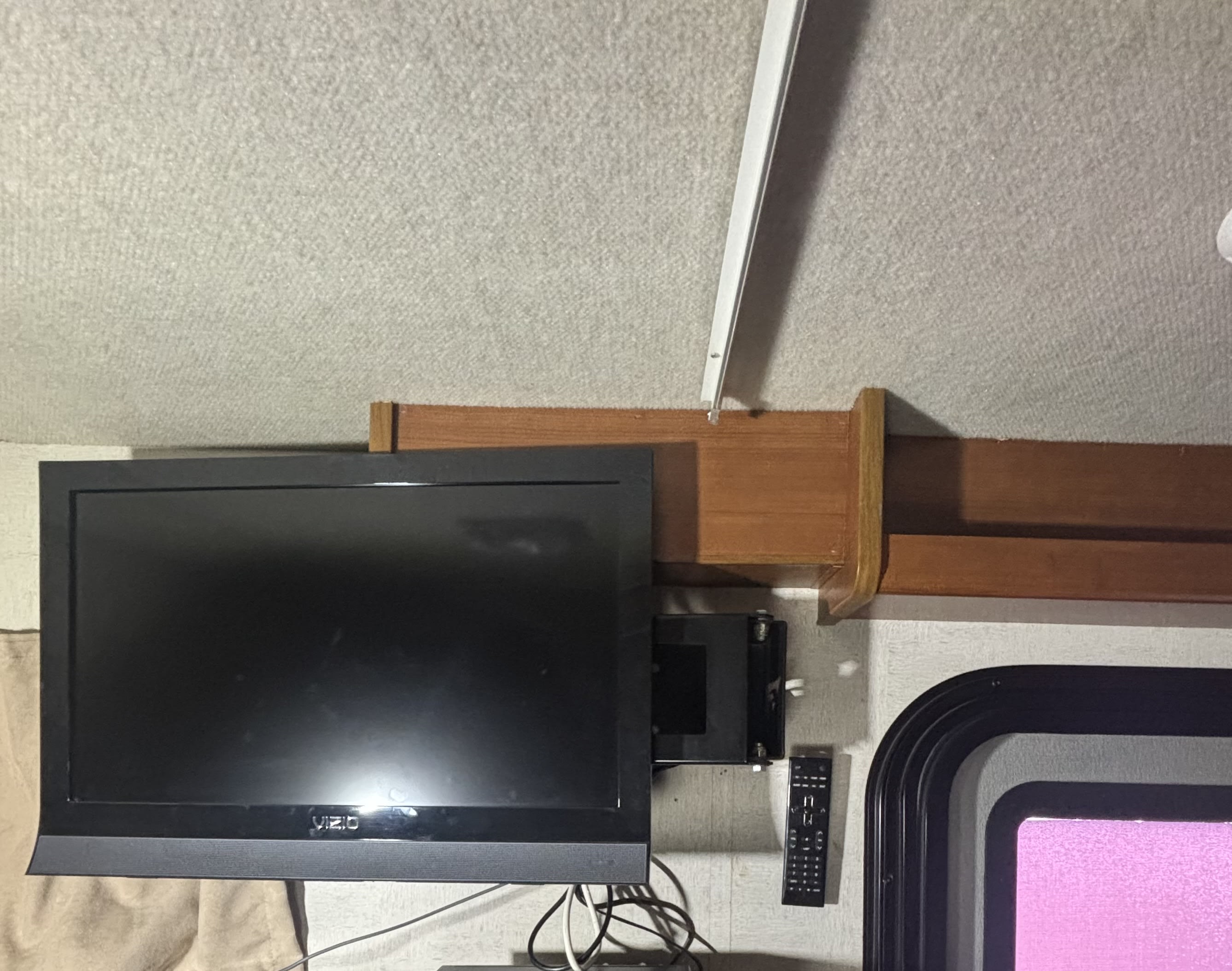 RV rental interior featuring a mounted Vizio TV for onboard entertainment, with remote and window visible.. Jamboree Sport 2011