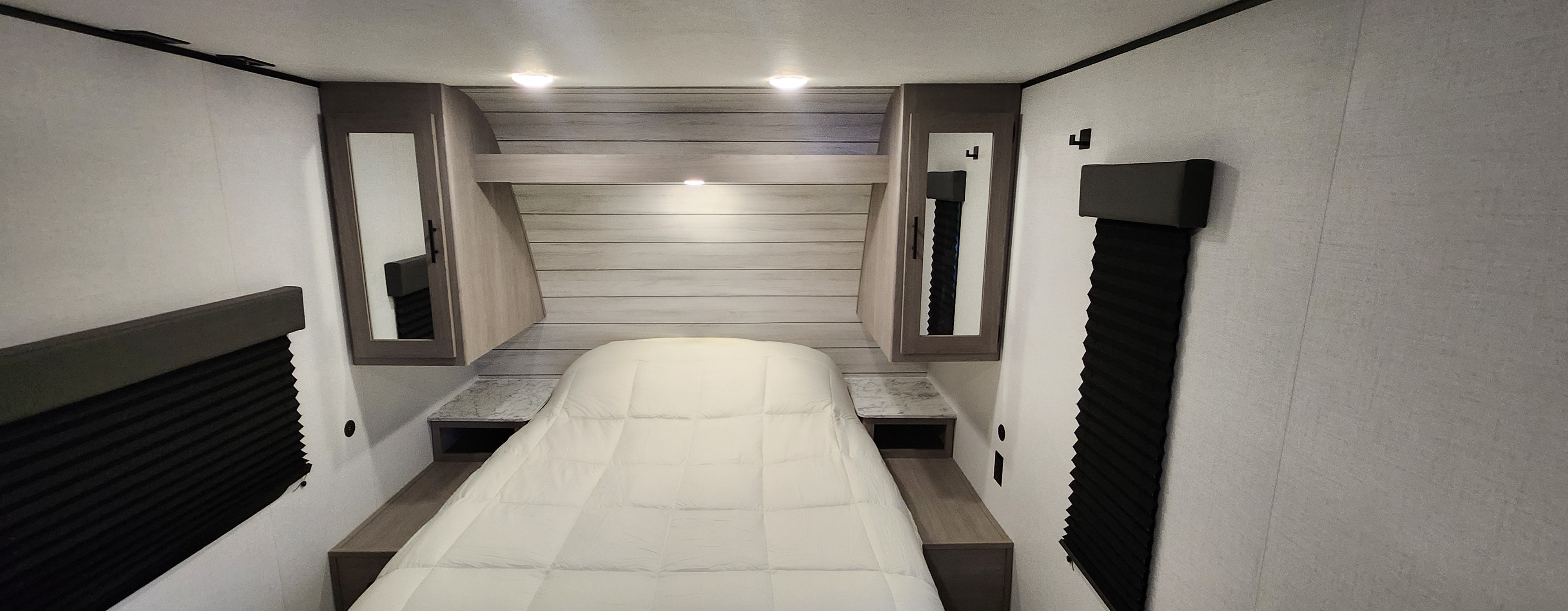 Cozy RV rental bedroom with bed, overhead cabinets, and blackout blinds for comfortable rest.. Coleman Lt274bh 2024