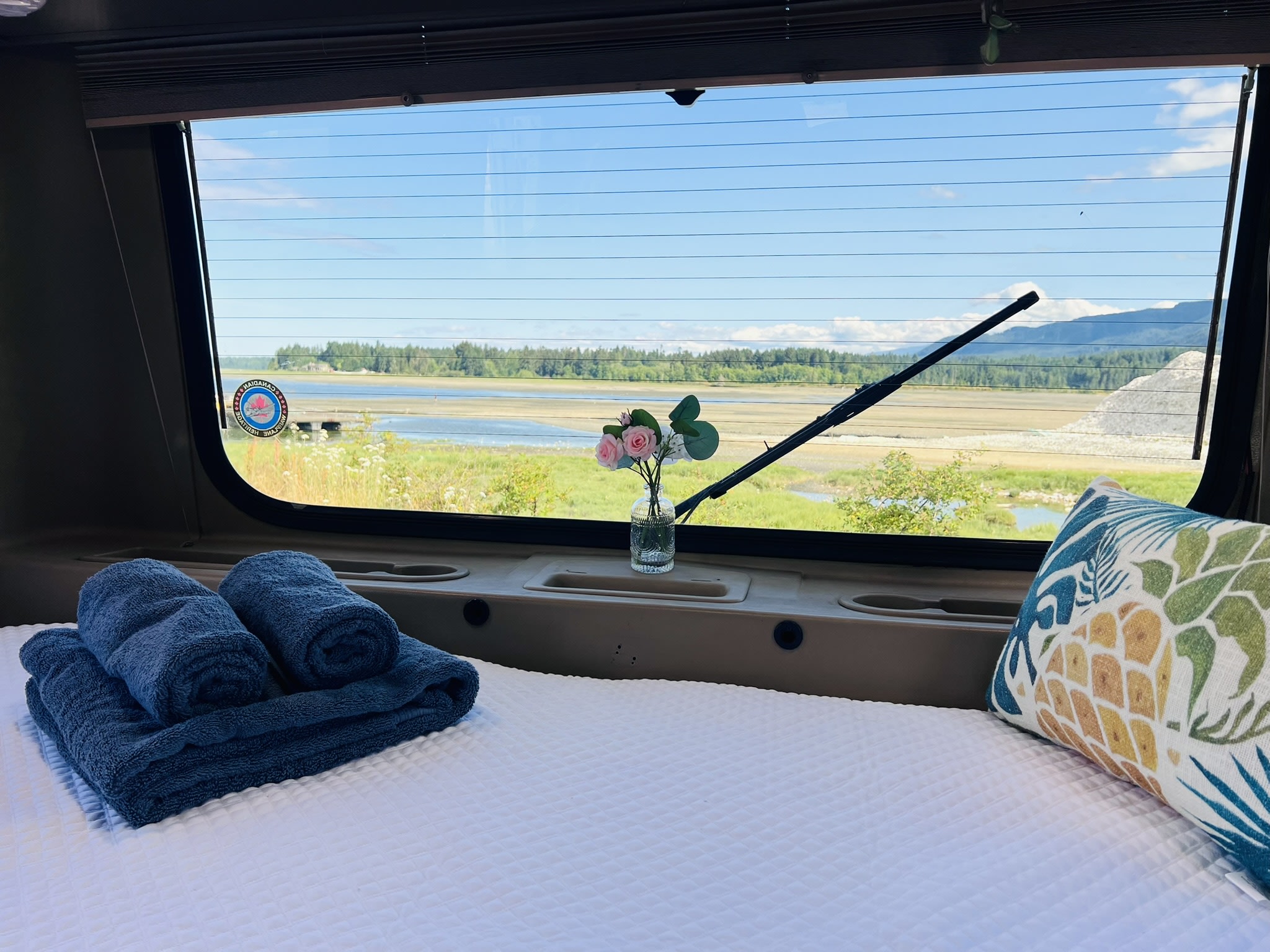 Experience an RV rental: Relax in a cozy bed with plush towels & decorative pillow, boasting a beautiful nature view.. Volkswagen Westfalia 1995