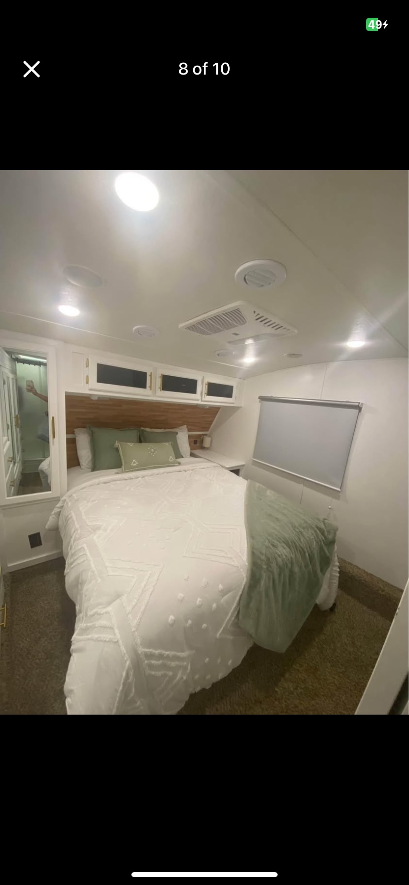 Spacious RV rental bedroom with a large bed, modern white interior, overhead storage, and green accents. Perfect for cozy travel.. Coachmen Chaparral 2019