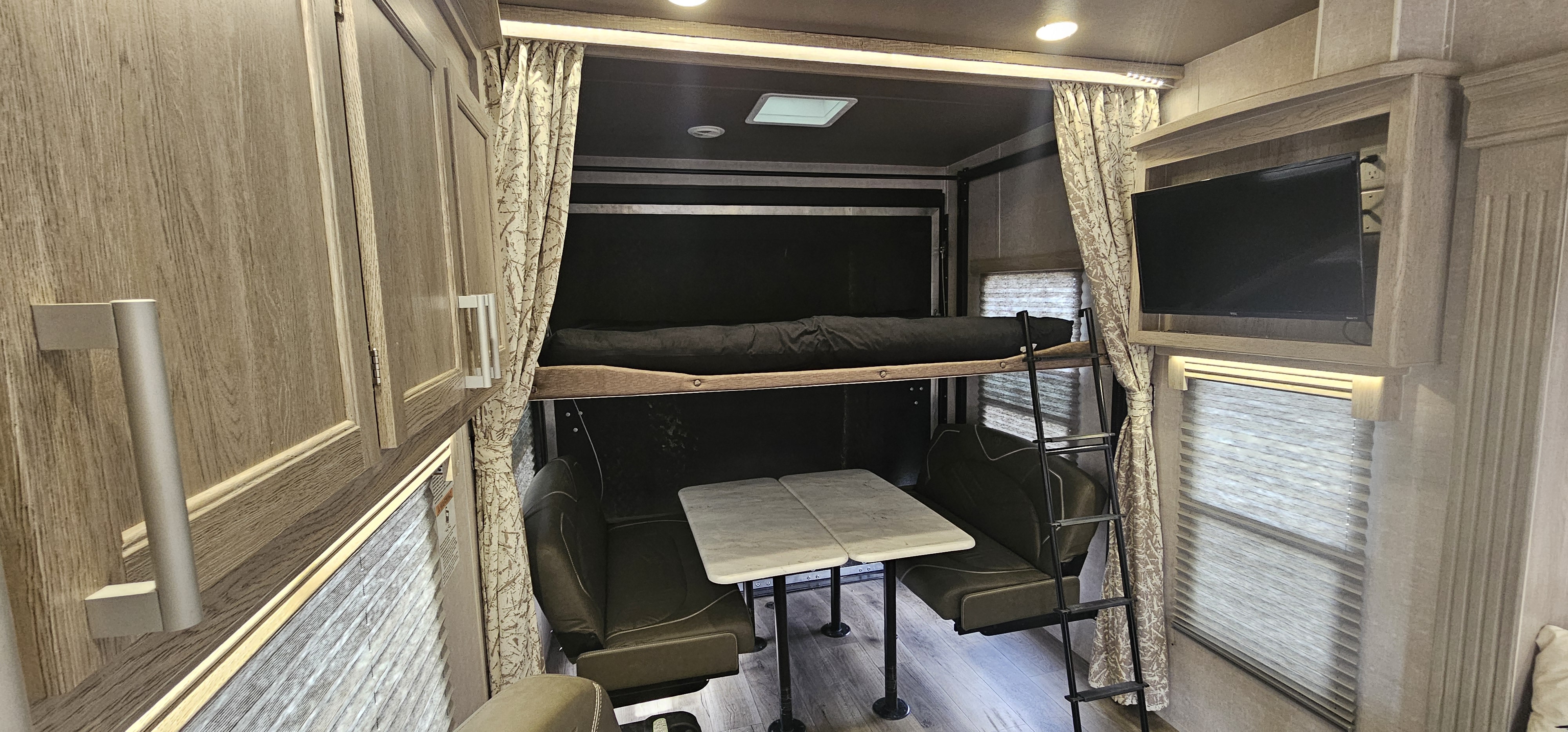 This RV rental features a versatile interior with a bunk bed, dining area, wall-mounted TV, and storage.. Eclipse Recreational Vehicles Attitude 2022