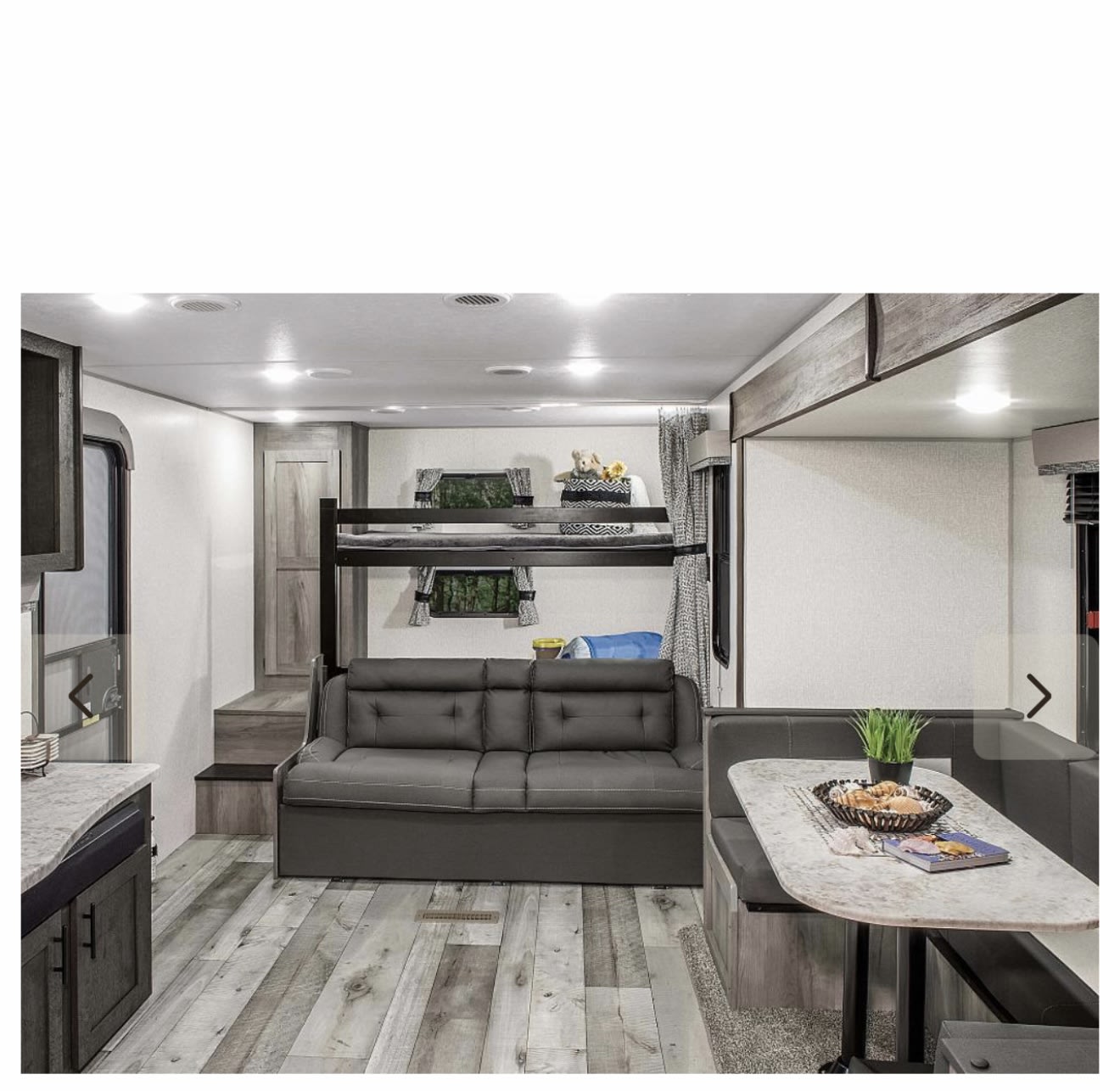 RV rental interior: Spacious camper living area with bunk beds, sleeper sofa, and dinette.. Sportsmen SE 2021