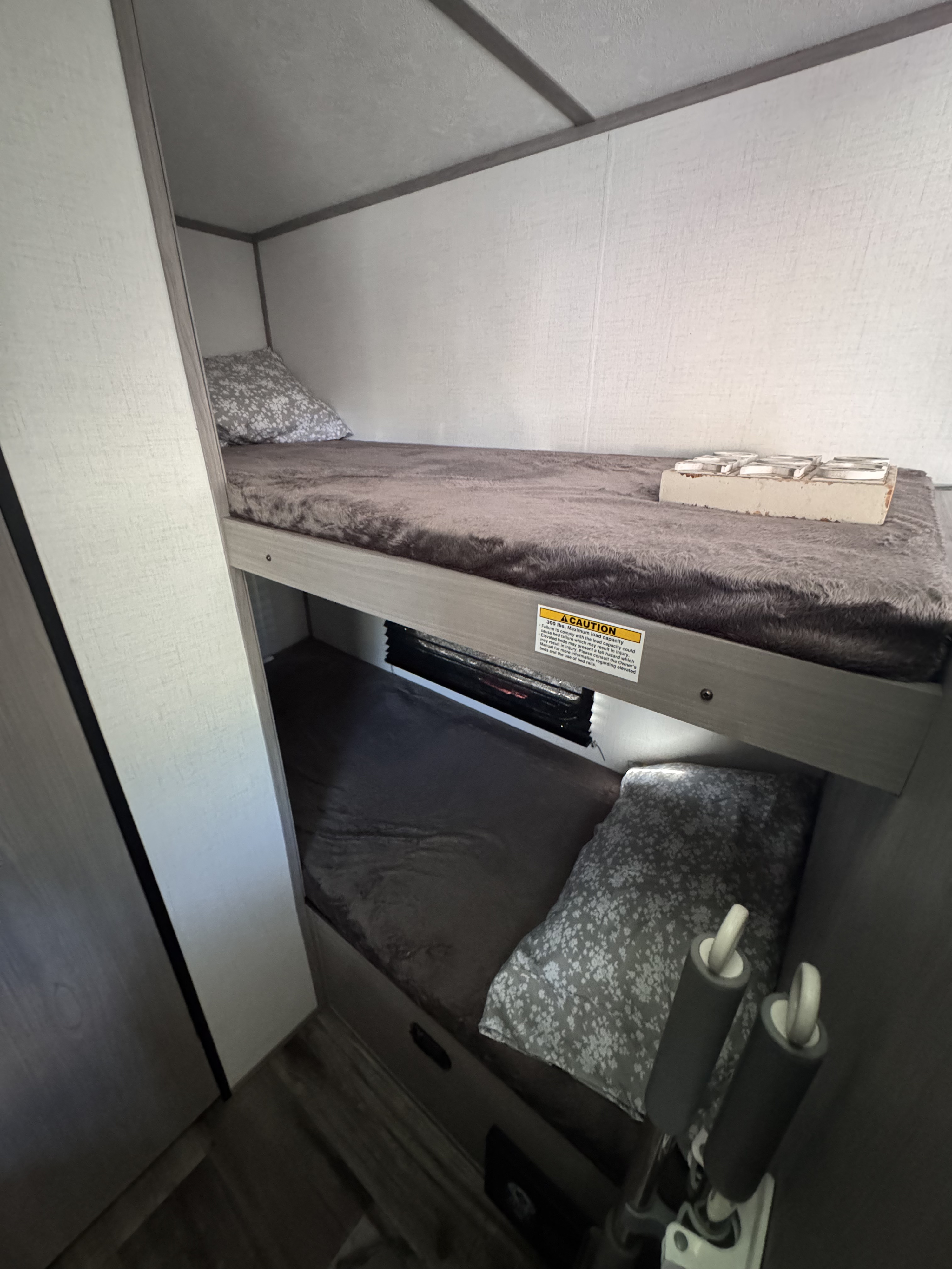 RV rental: Two gray bunk beds with soft bedding and pillows, perfect for compact sleeping in a travel trailer.. Dutchmen Coleman Lantern LT 2023