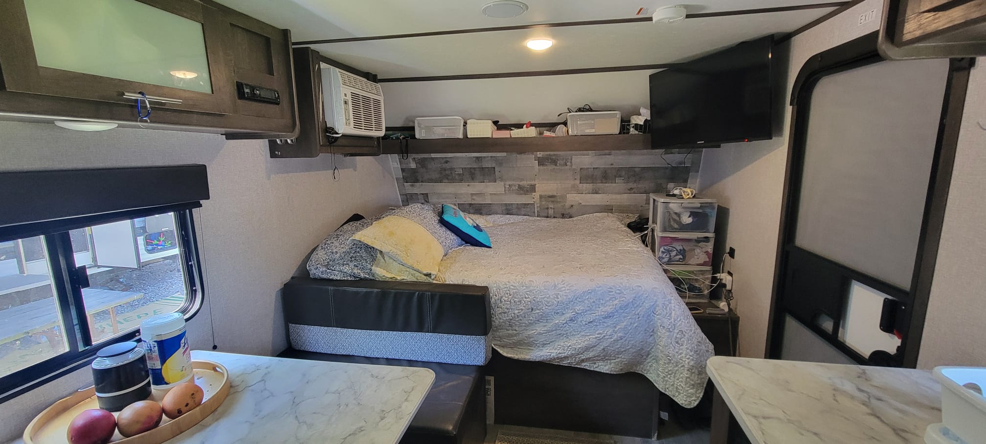 This RV rental features a cozy living space: bed, TV, AC, window, and small table area.. Keystone RV Coleman Lantern 17B 2021