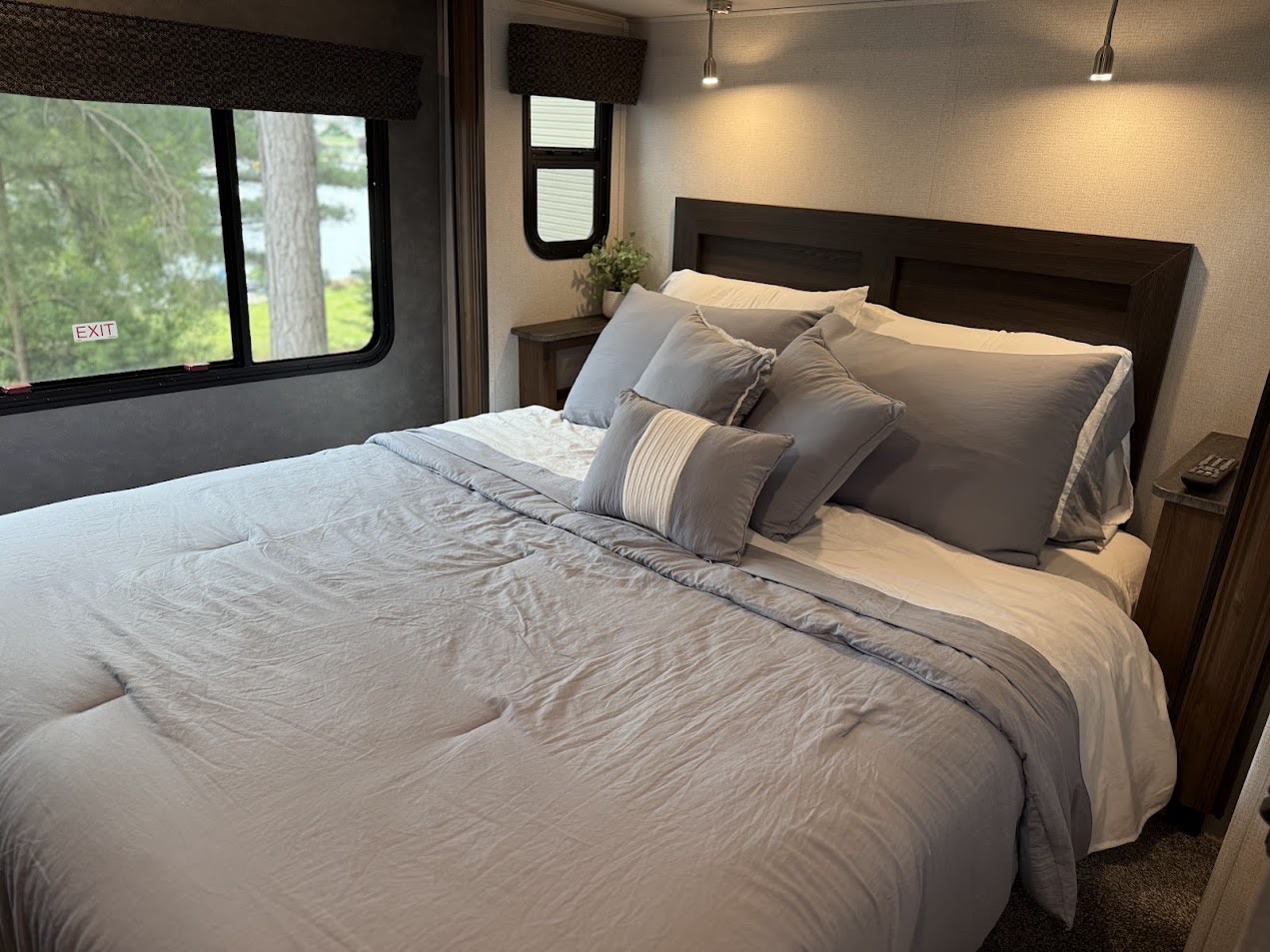 Cozy RV rental bedroom with a comfy bed, lake view, and handy emergency exit window, ideal for travel.. Forest River Sunseeker Classic 2022