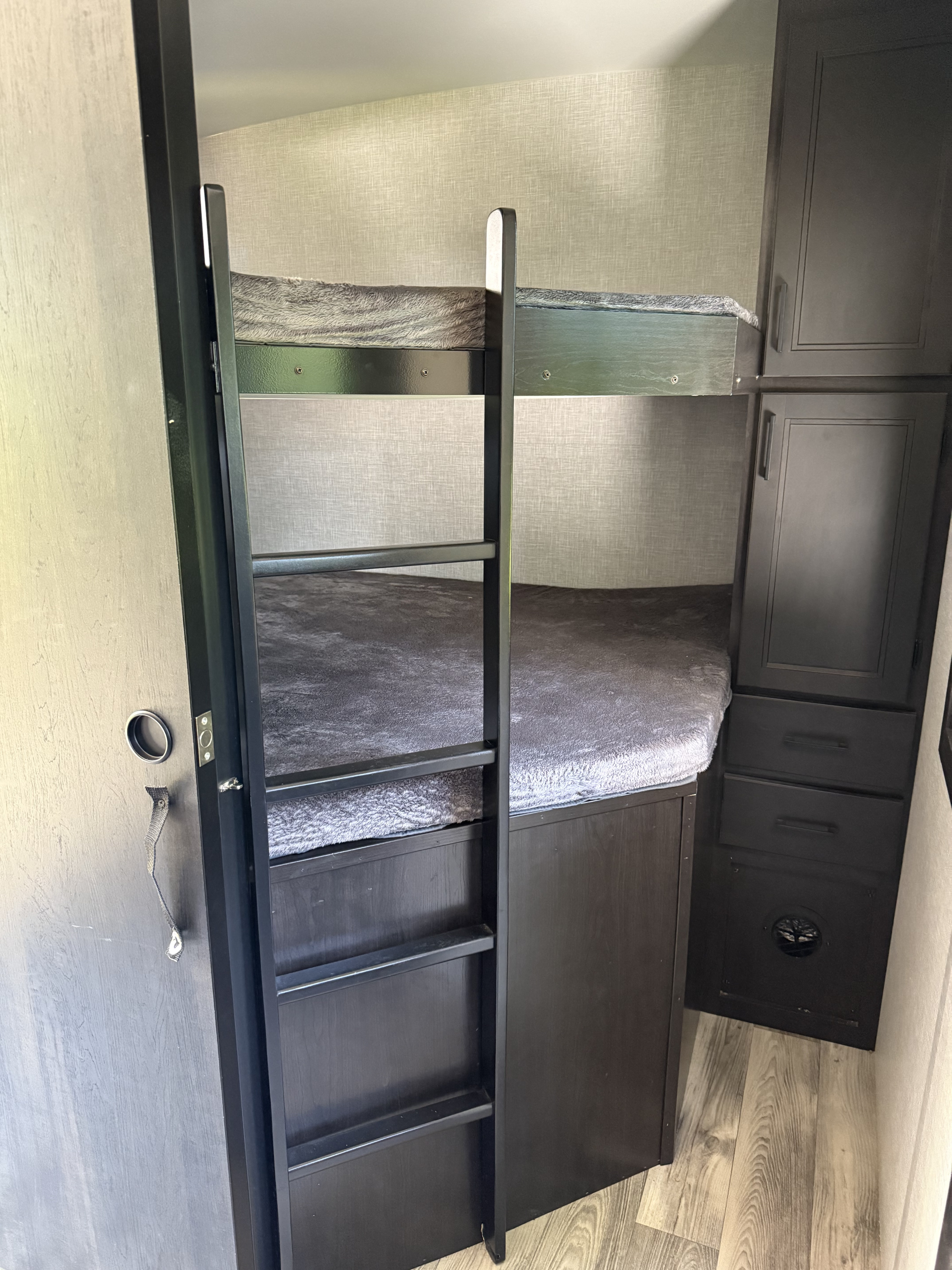 RV rental bunk beds with a ladder and built-in storage cabinets, ideal for family travel in a camper.. Starcraft 296bhs 2023
