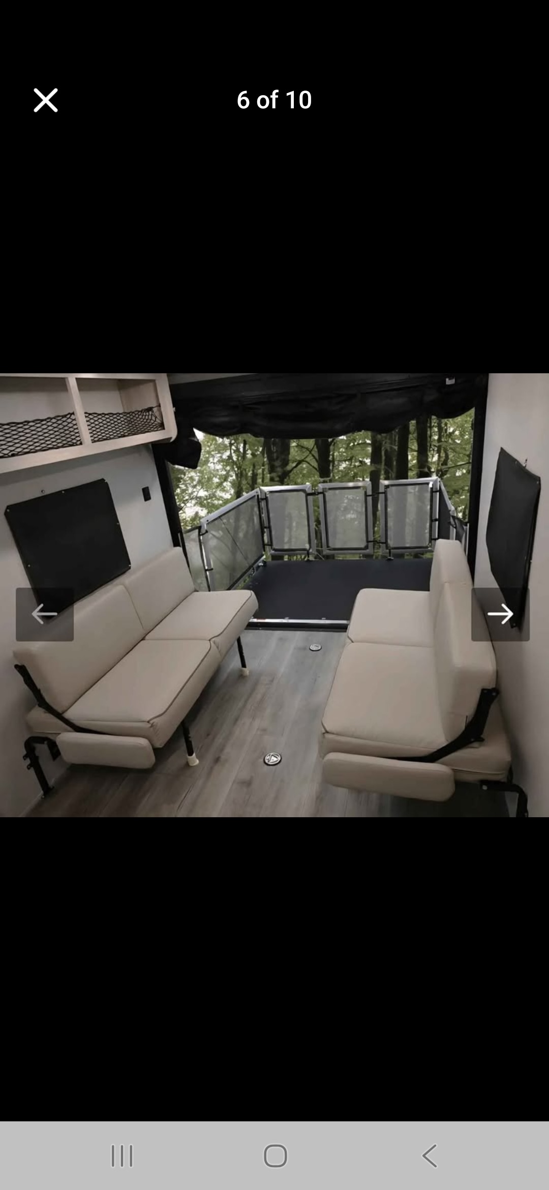 RV rental interior shows two sofas facing a rear patio deck with railings, overlooking a forest view.. Coachmen Catalina 2025