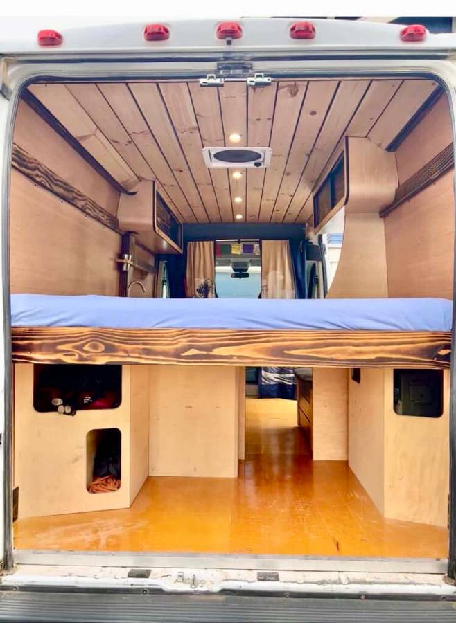 Explore van life! This cozy rv rental showcases a custom wooden interior with a comfy raised bed and smart storage.. Dodge Sprinter Van 2017