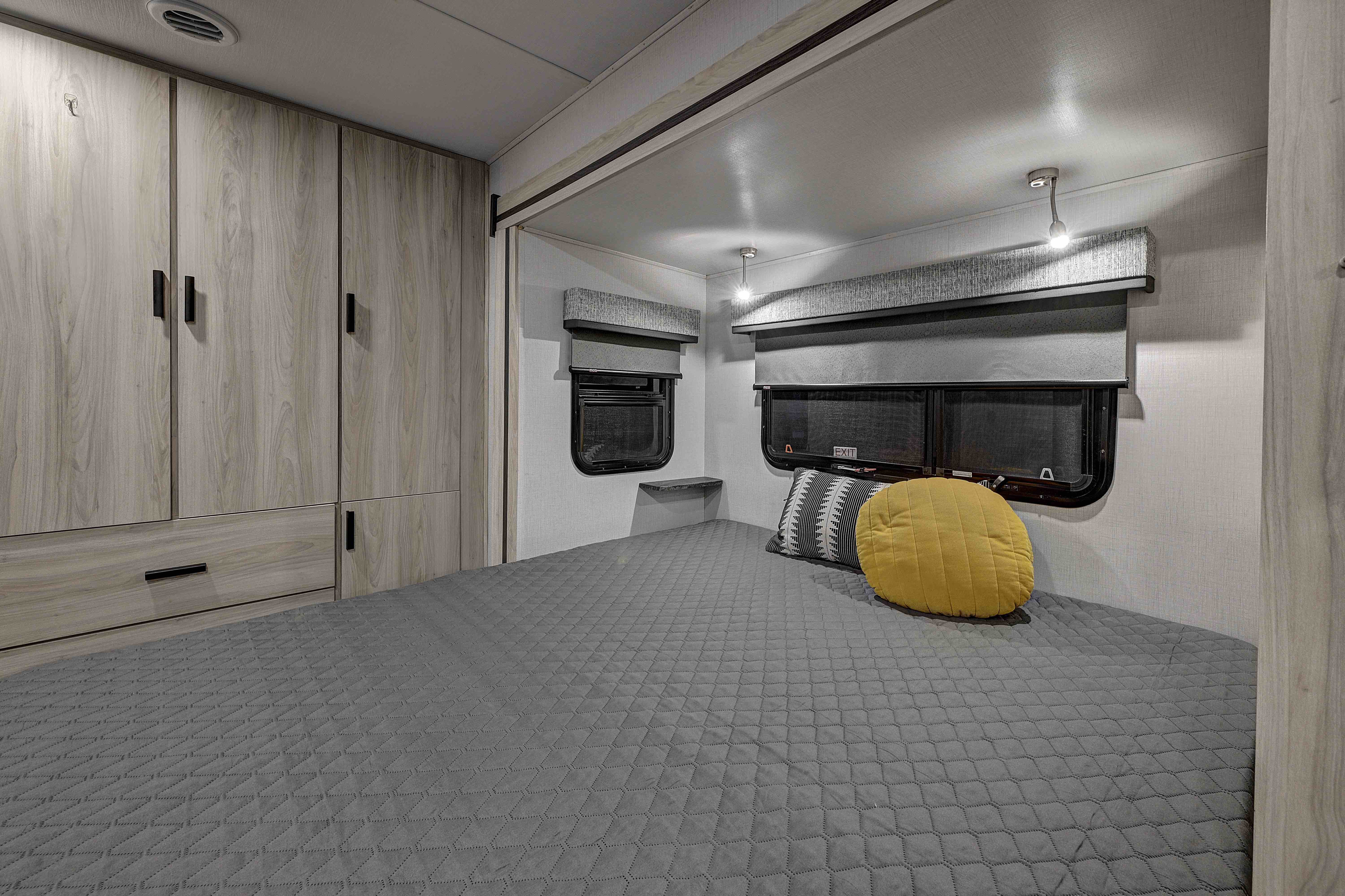 Comfortable RV rental bedroom with modern furnishings, including a cozy bed, ample wardrobe storage, and windows.. Forester MBS 2023