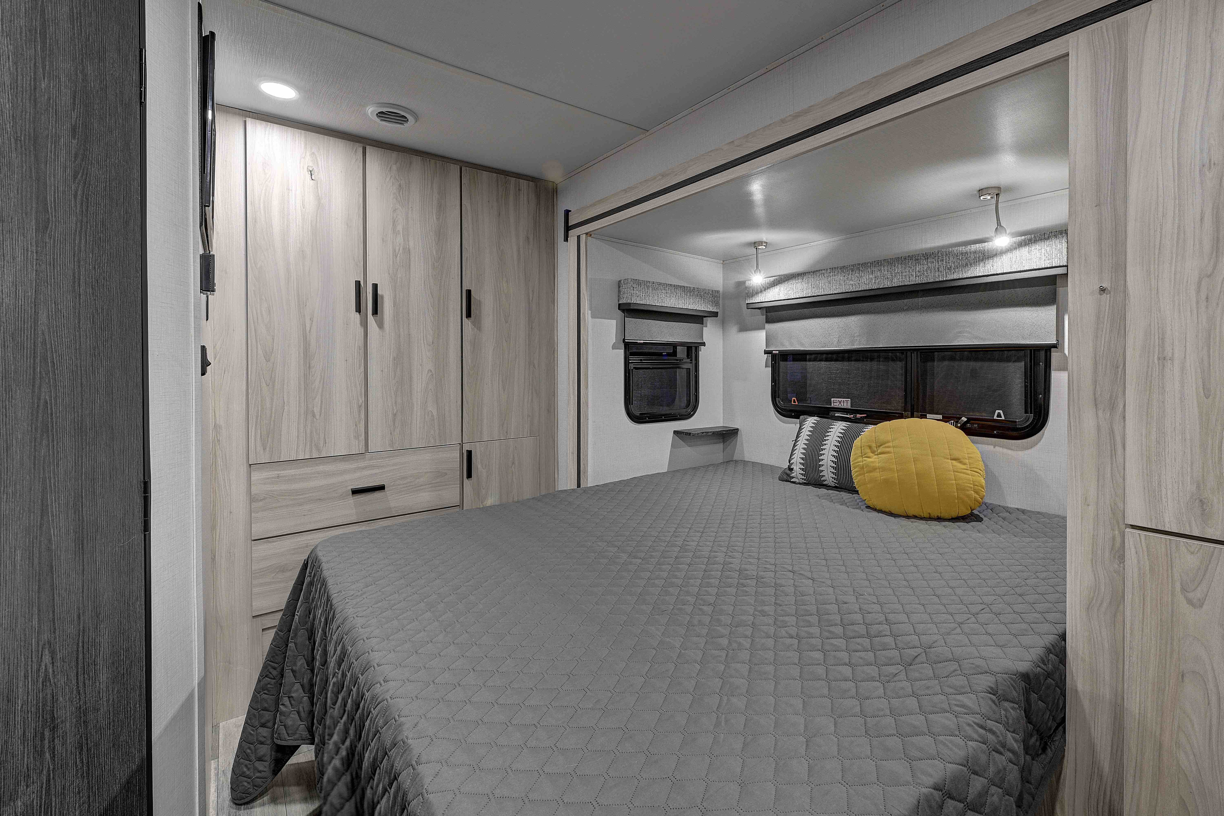 Spacious RV rental bedroom featuring a comfy queen bed, modern cabinetry, and windows for your next adventure.. Forester MBS 2023