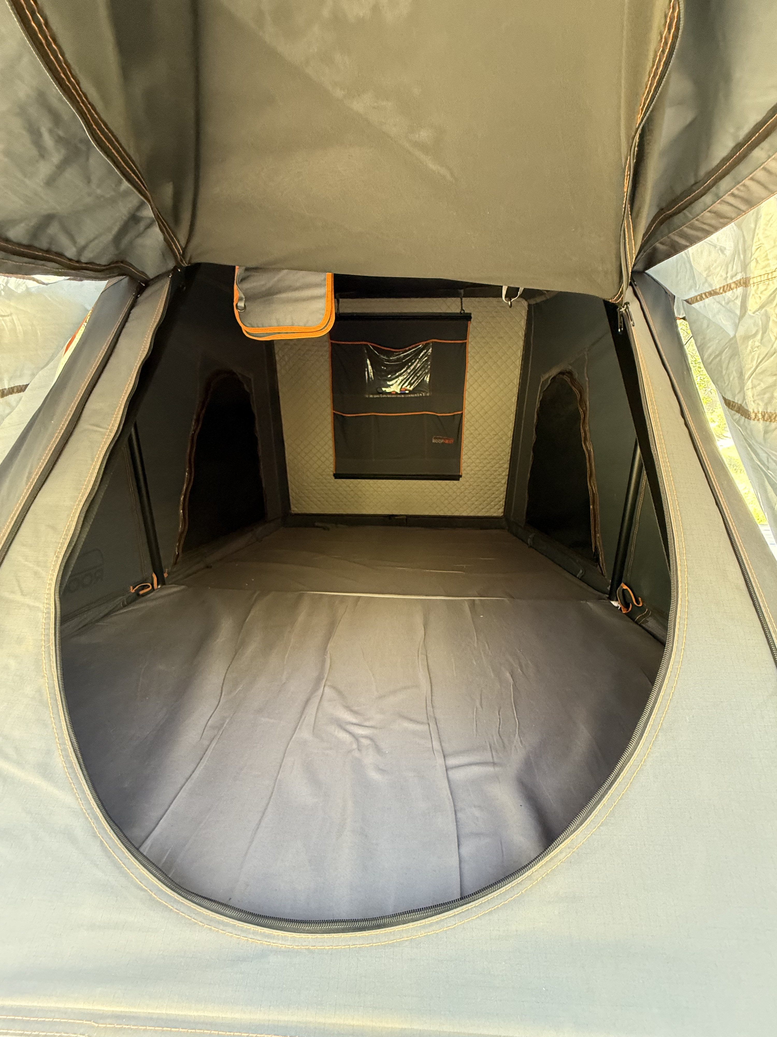 View of a Roofnest rooftop tent interior, ideal for your RV rental adventures. Features a bed area & hanging storage.. Toyota Tundra with Roofnest Tent 2010