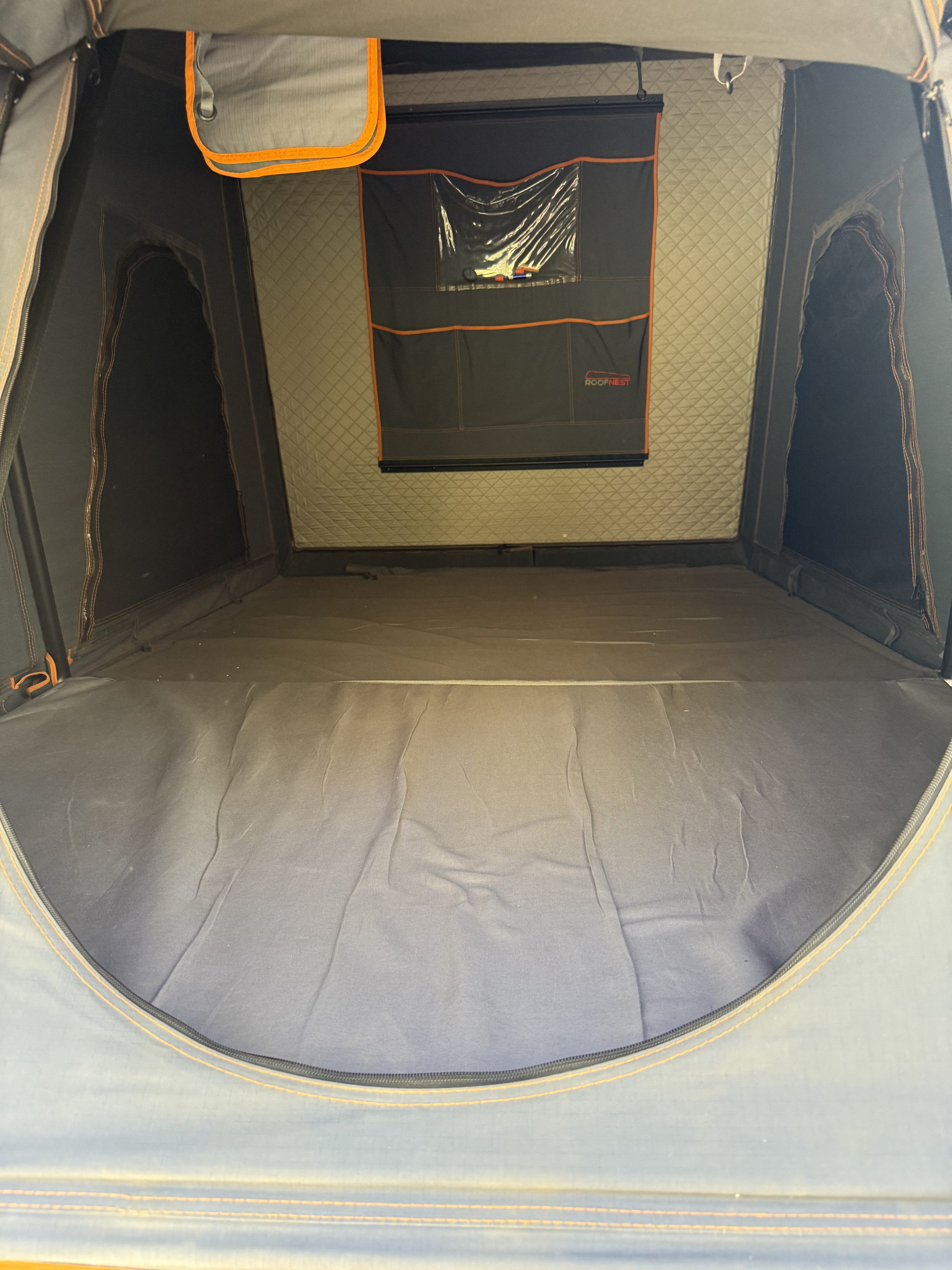Inside a comfy RV rental rooftop tent, showing the sleeping area, insulated walls, and an organizer. Ideal for camping trips.. Toyota Tundra with Roofnest Tent 2010