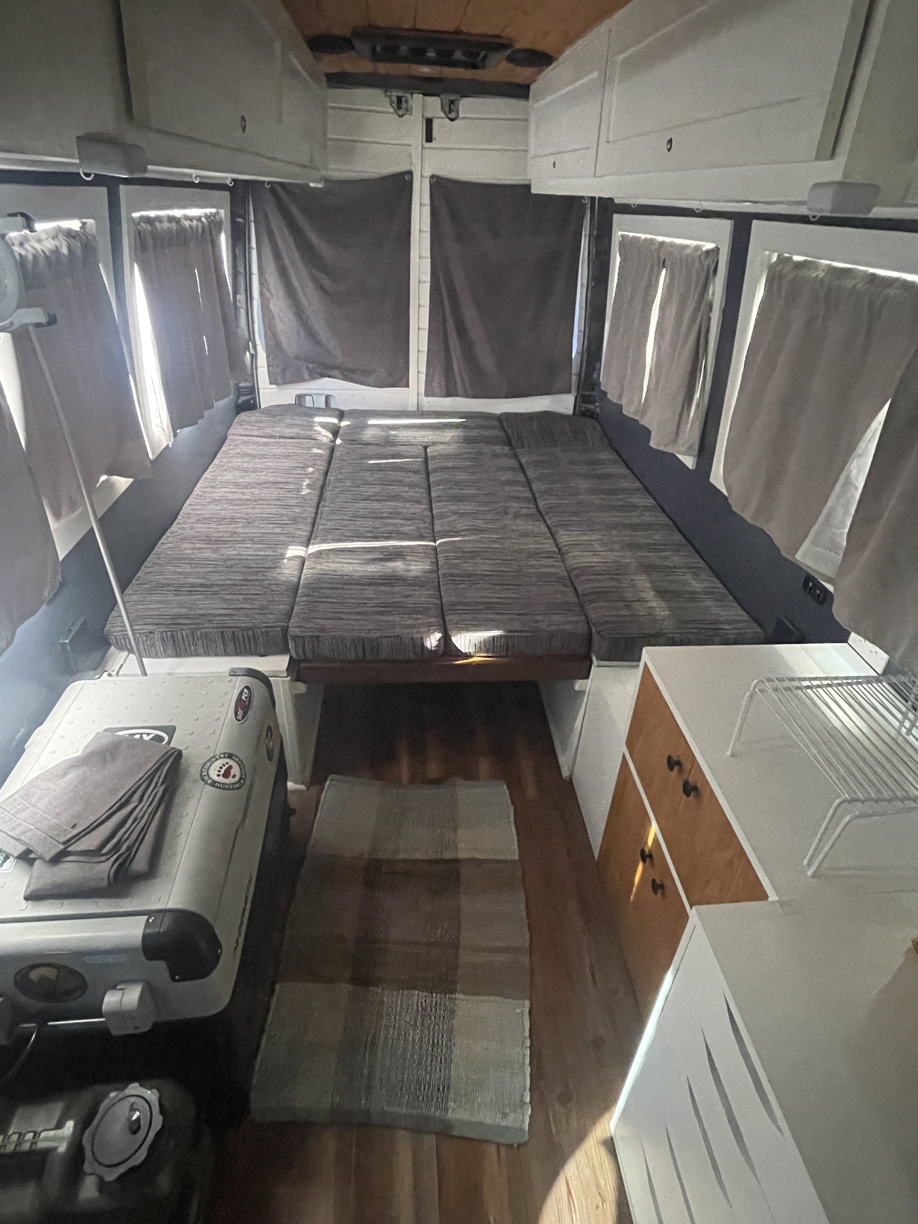Inside this modern RV rental: a flexible bed/seating area, overhead storage, and a compact kitchen. Ready for adventure!. Mercedes-Benz Sprinter 2014