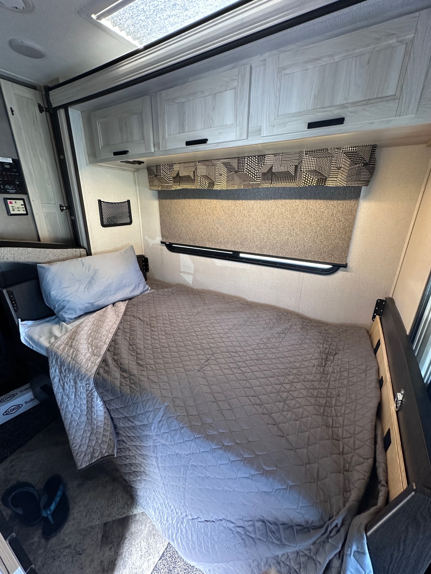 Cozy RV rental interior with a comfortable single bed, overhead cabinets, and window, ready for your adventure.. Forest River Sunseeker Classic 2021