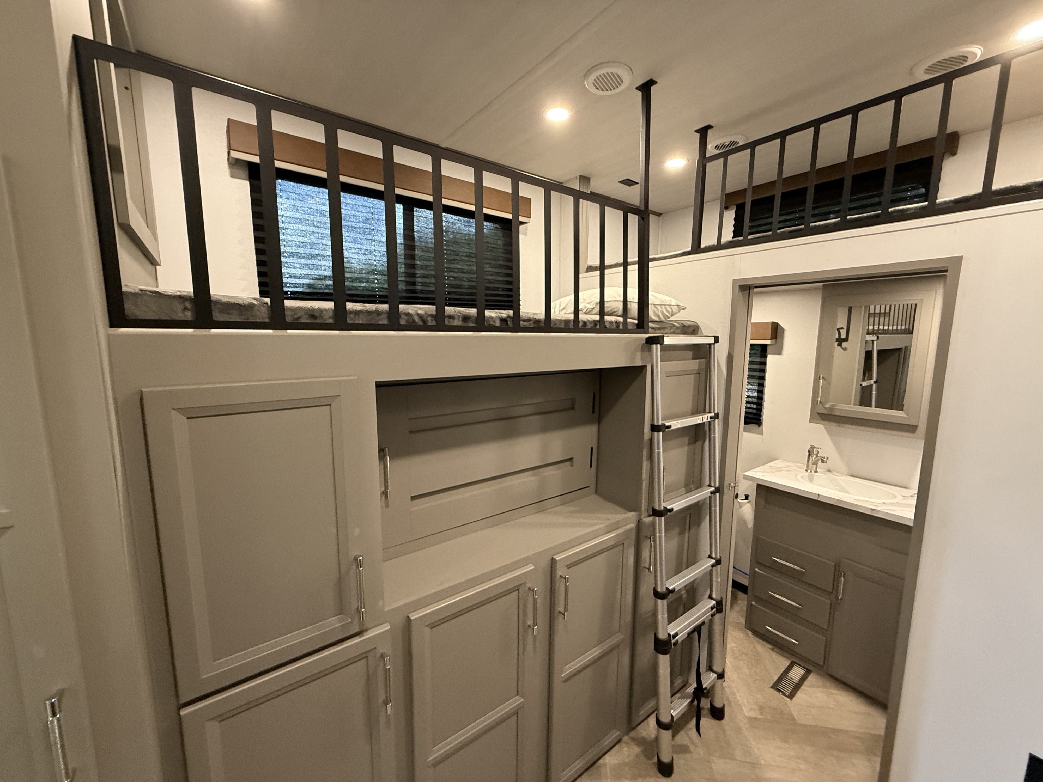 Modern RV rental interior: stacked bunk beds, ladder access, integrated storage, and a convenient compact bathroom.. Keystone Sprinter Wide Body 2025