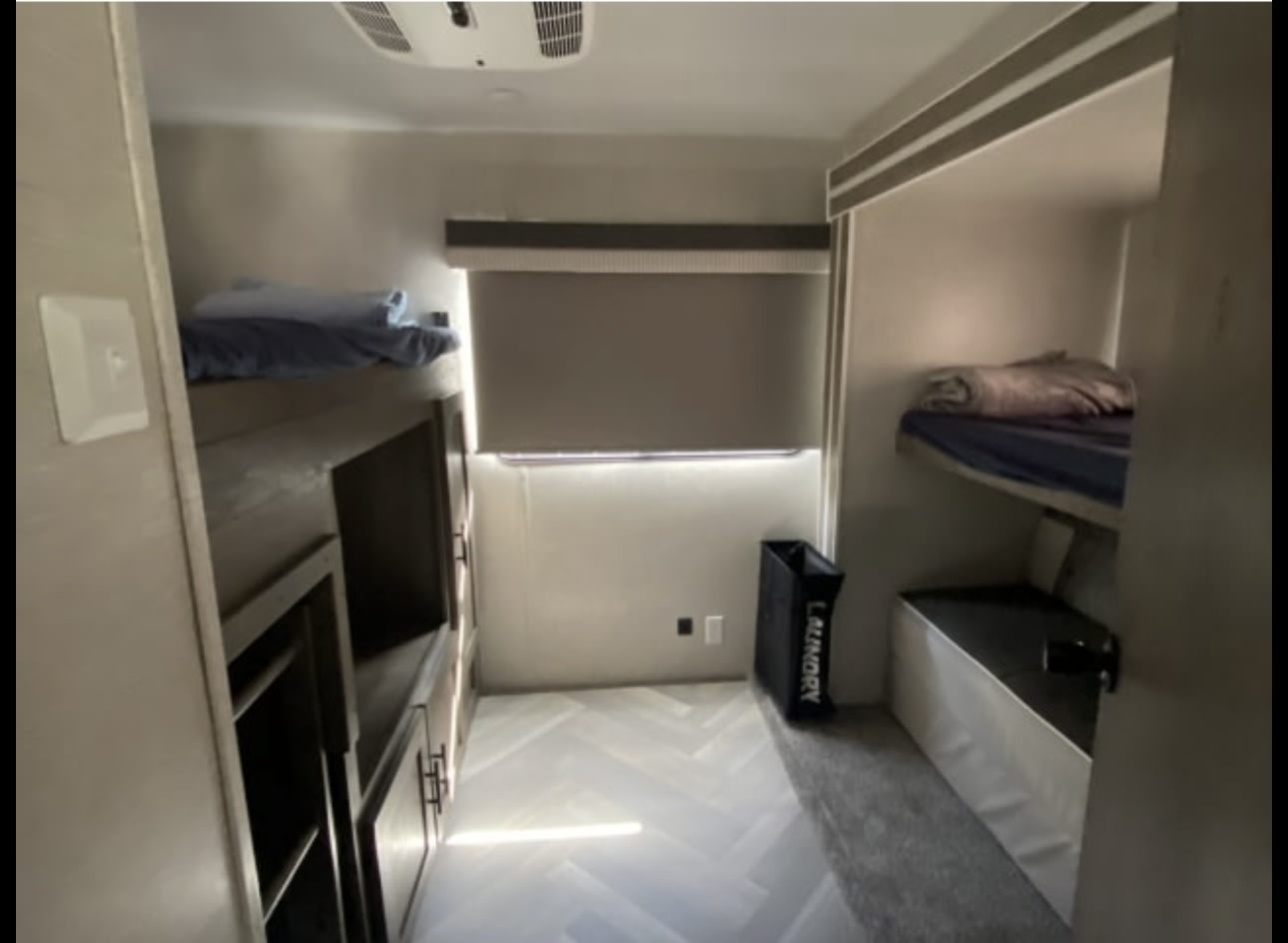 Well-equipped RV rental bunkhouse with two bunk beds, storage, and window, ideal for families.. Forest River Wildwood 2021