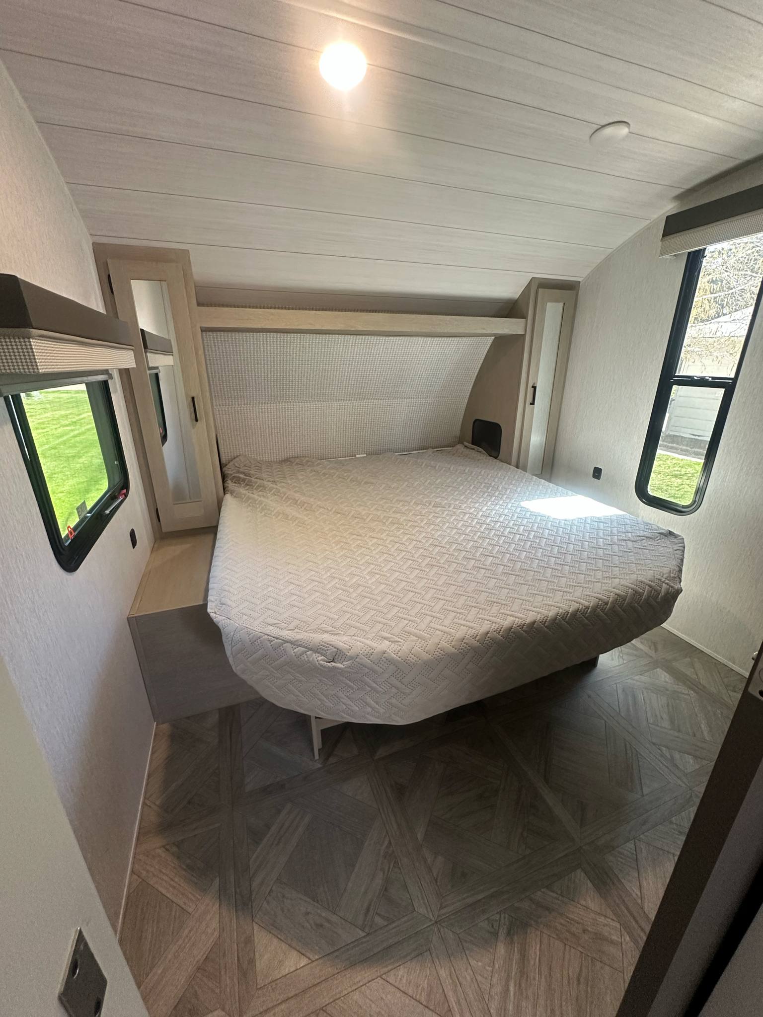 Modern RV rental bedroom featuring a comfy bed, built-in storage, and windows, ideal for travel.. Forest River Salem Cruise Lite 2024