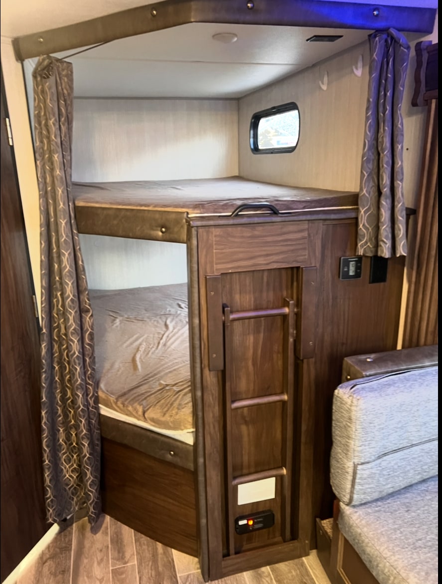 Inside this RV rental, comfortable bunk beds offer sleeping space. Featuring a ladder and window.. Forest River Cherokee Grey Wolf 2019