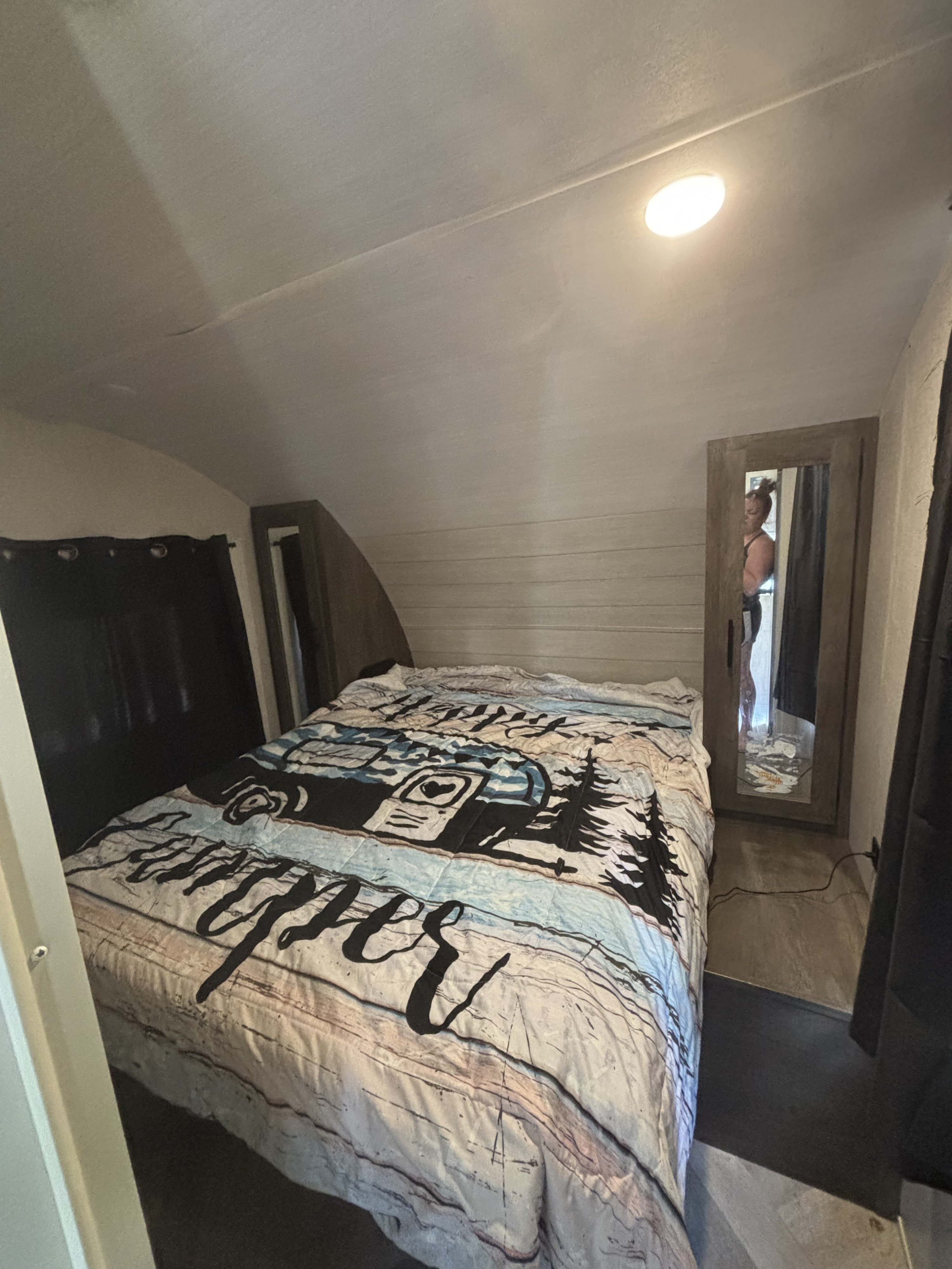 Cozy RV rental bedroom with a themed comforter & mirror. Perfect for your next travel trailer adventure.. Forest River Salem Cruise Lite 2021