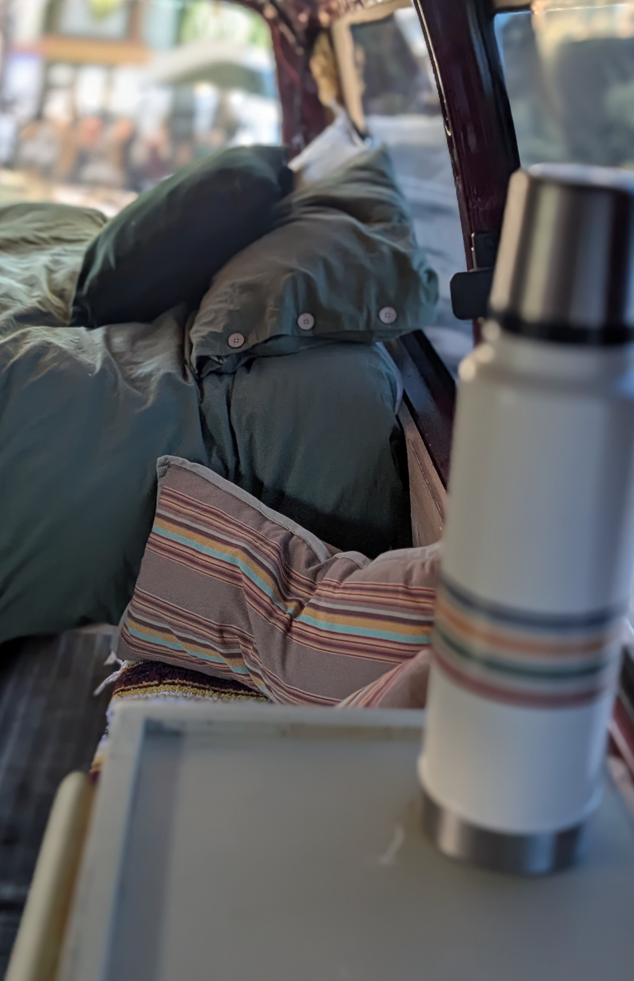 Cozy RV rental interior with green bedding & thermos, perfect for adventure.. Chevrolet Express 3500 2007