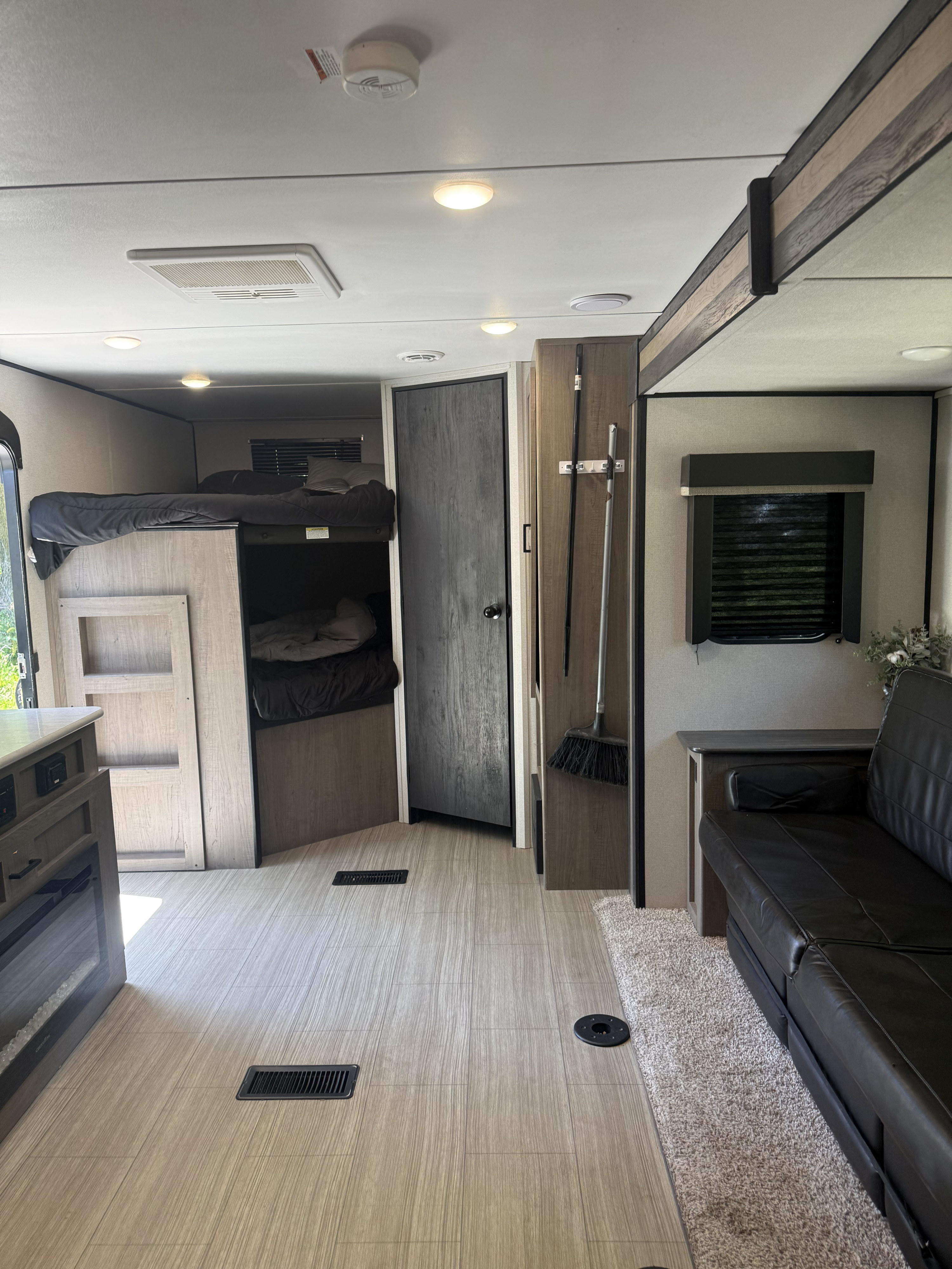 Explore the cozy interior of this RV rental, featuring bunk beds, a comfy couch, and a well-designed living space.. Keystone Hideout 250 BH 2021