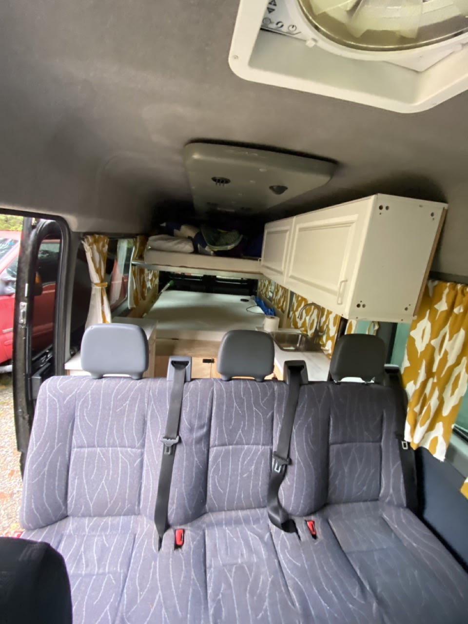 RV rental: Van conversion interior with rear seating, raised bed, & cabinets. Ideal for road trips & camping.. Dodge Sprinter 2006