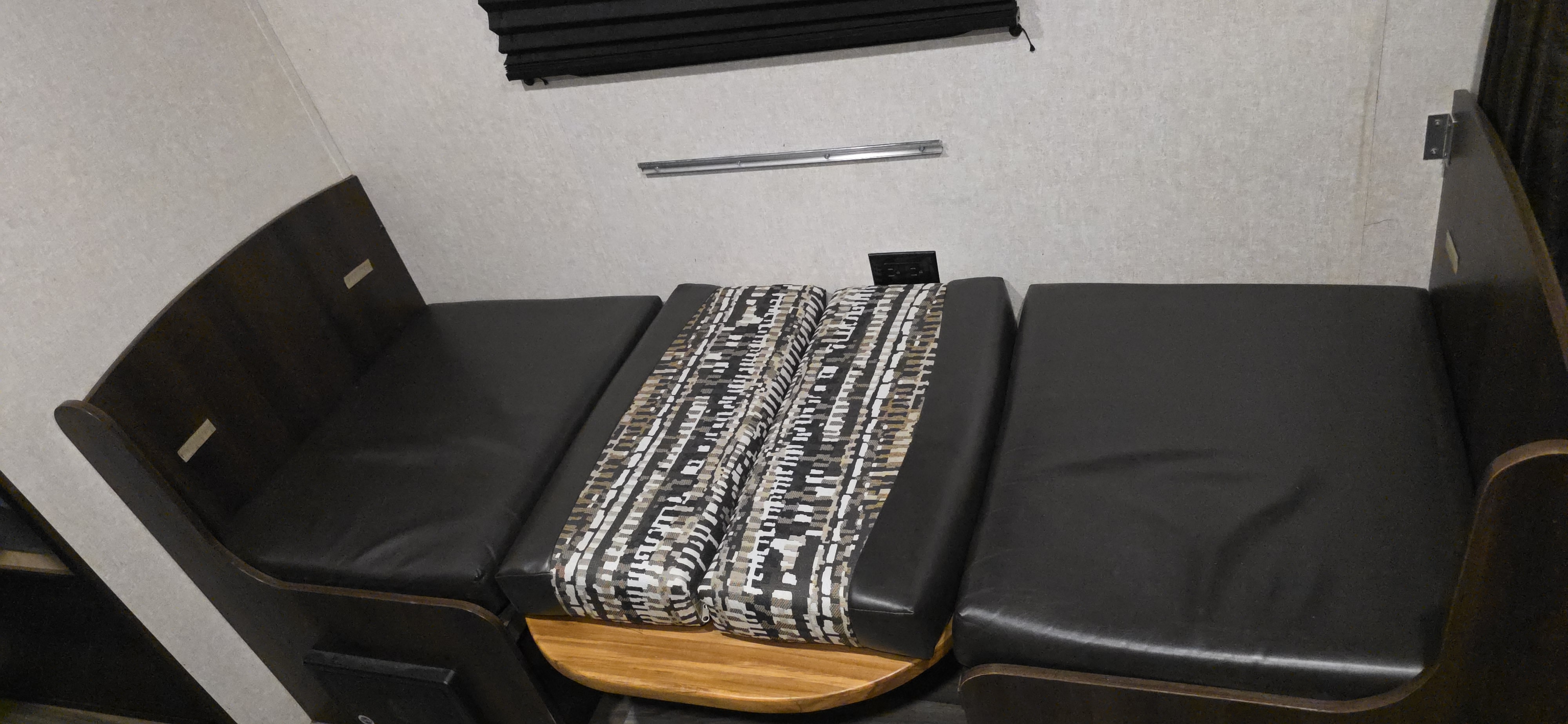 RV rental dinette: dark bench seats with a convertible table and patterned cushions, offering versatile seating & sleeping.. Jayco Jay Flight SLX 2018
