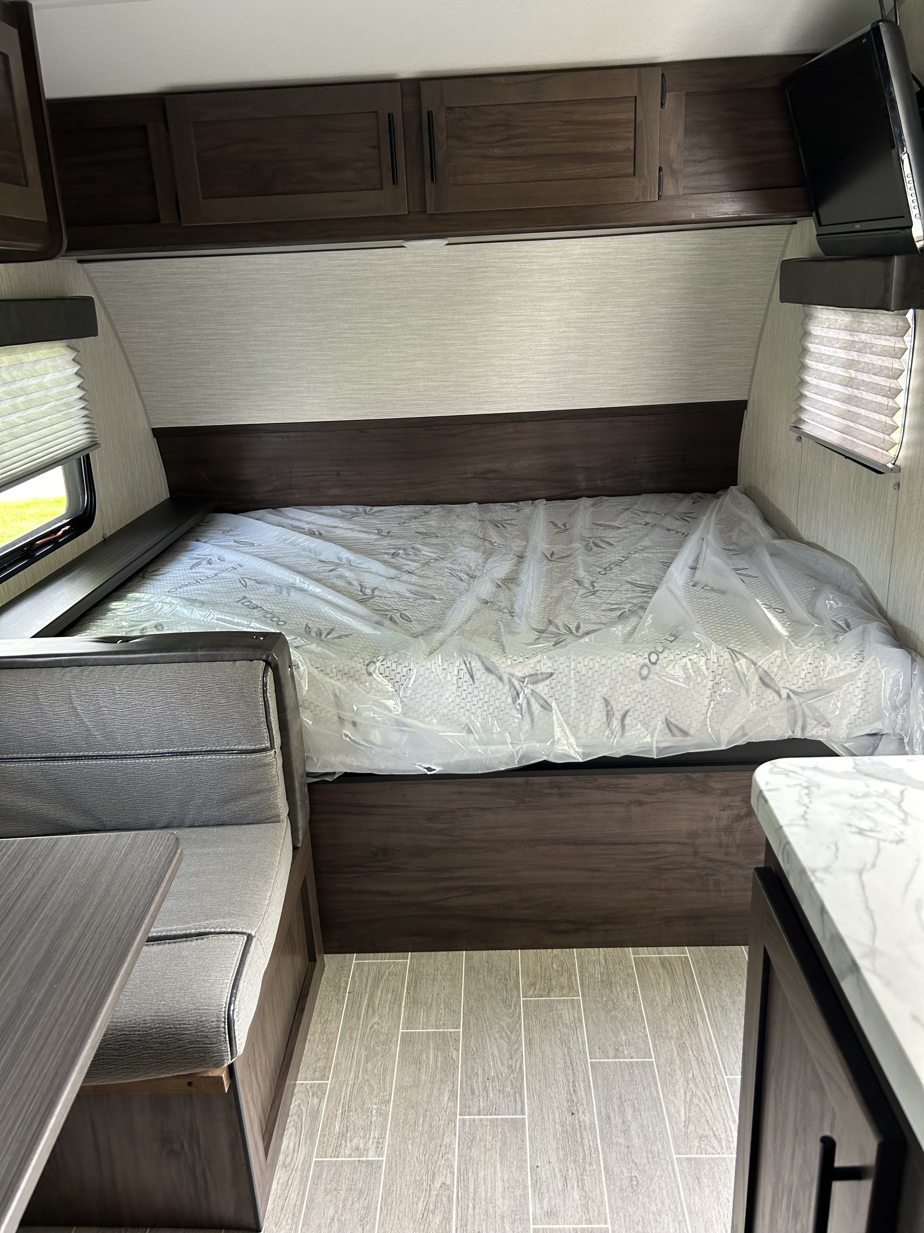 RV rental interior: a new mattress bed, overhead cabinets, dinette, and mounted TV. Ready for adventure.. Forest River Cherokee Wolf Pup 2020