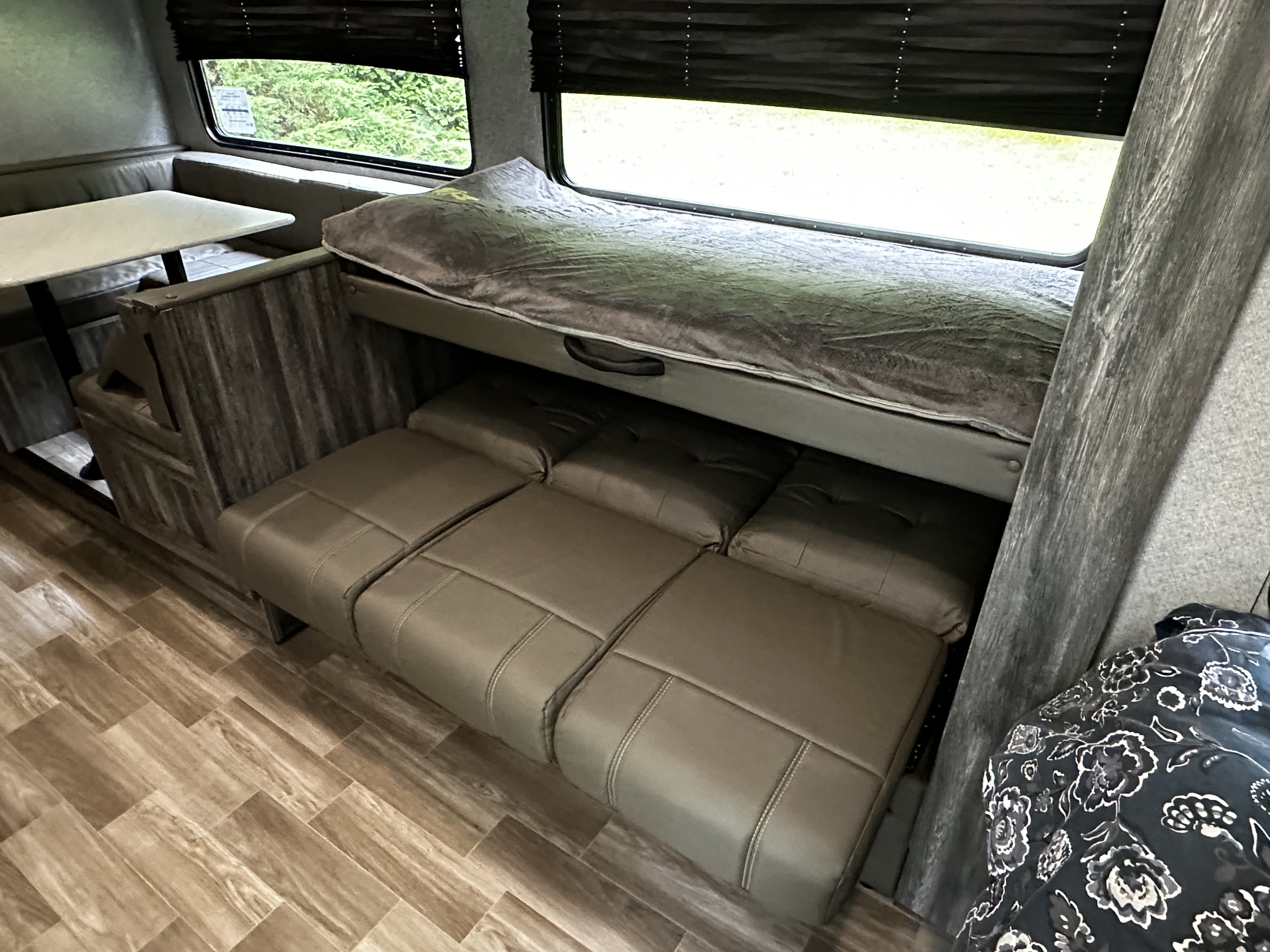 Inside an RV rental: a flexible living area featuring a dinette, upper bunk, and a lower convertible sofa bed.. Forest River Salem FSX 2020