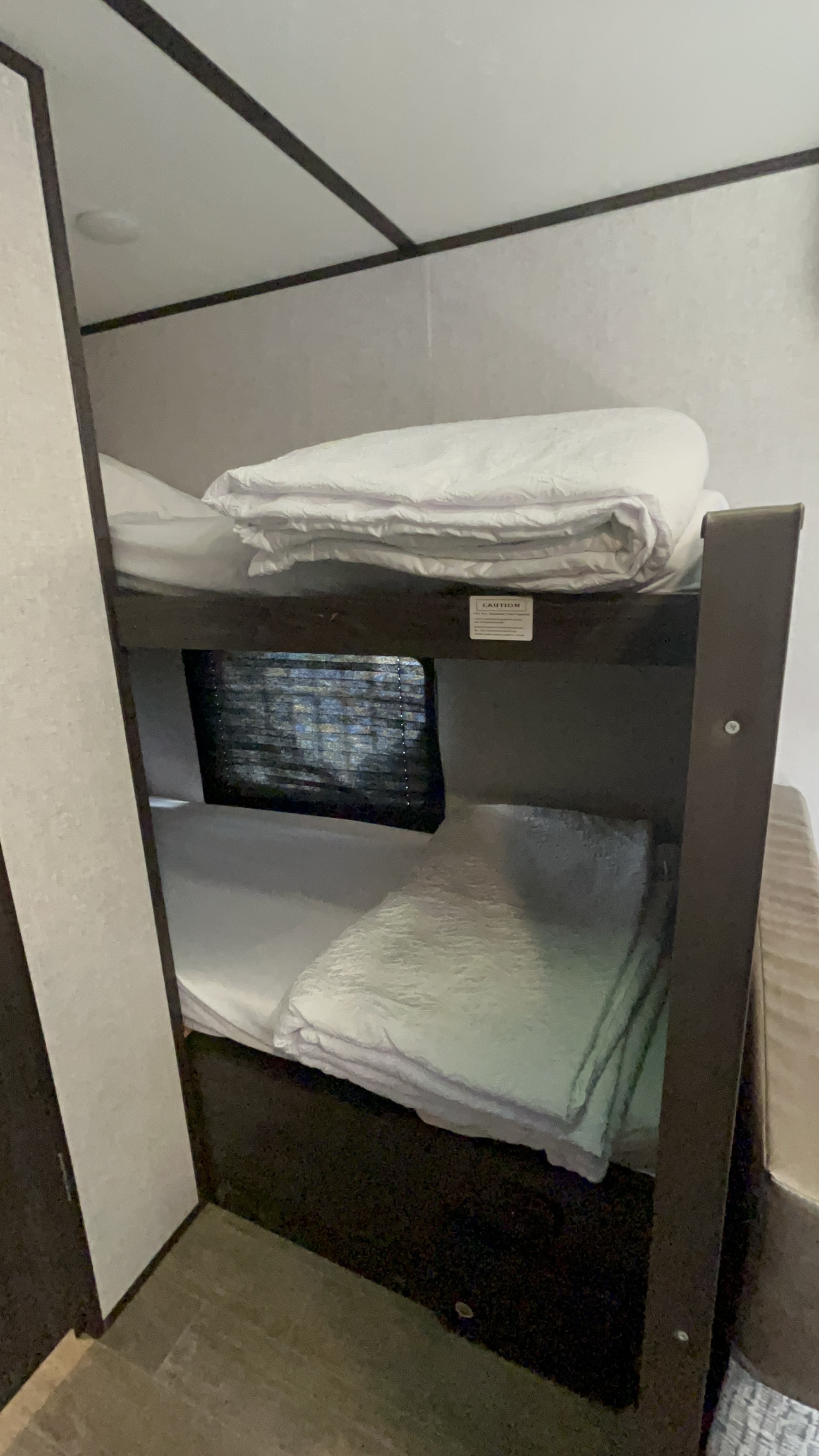 Comfortable bunk beds in an RV rental, perfect for families. Enjoy compact sleeping space on your travels.. Dutchmen Coleman 2021