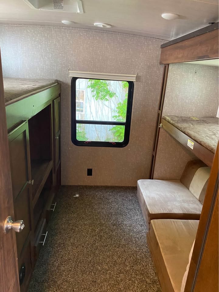 RV rental interior shows a compact bunk room with multiple beds, seating, and storage on carpeted floor.. Heartland RVs Mallard 2019